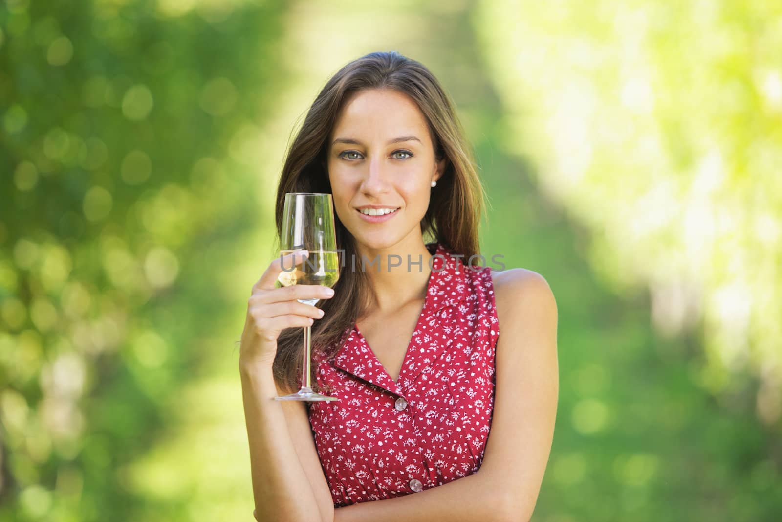 Portrait of woman in vineyard with a glass of champagne