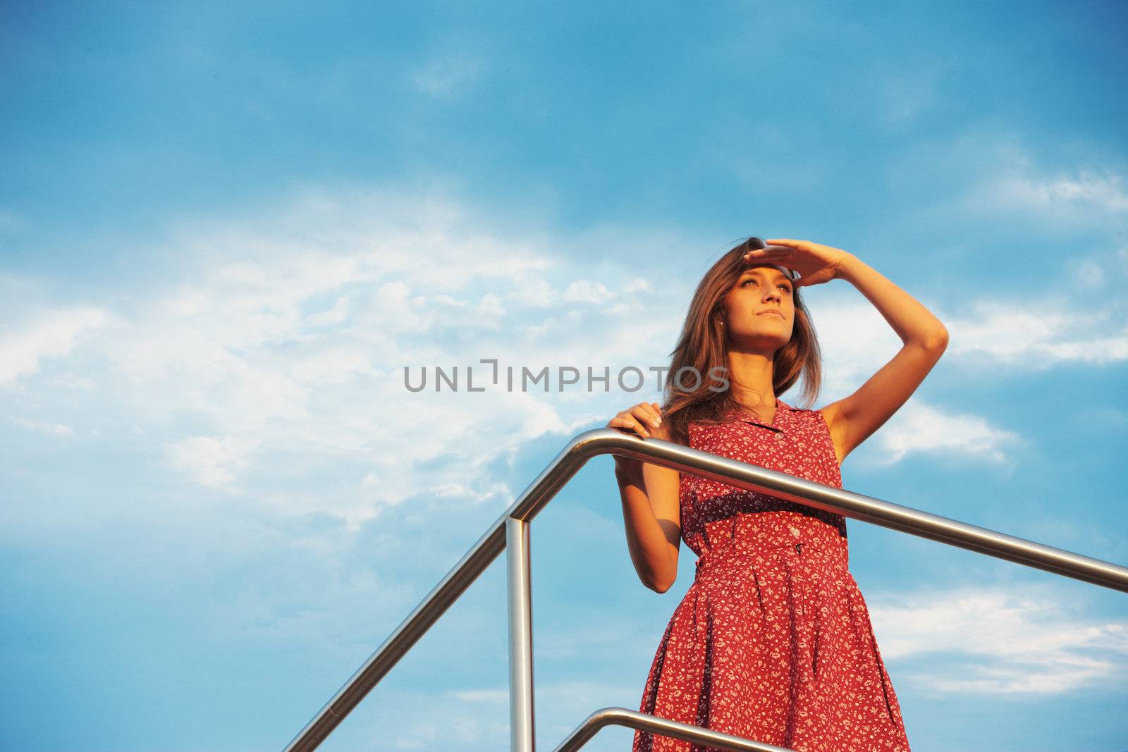 Young woman looking far away in sunset light