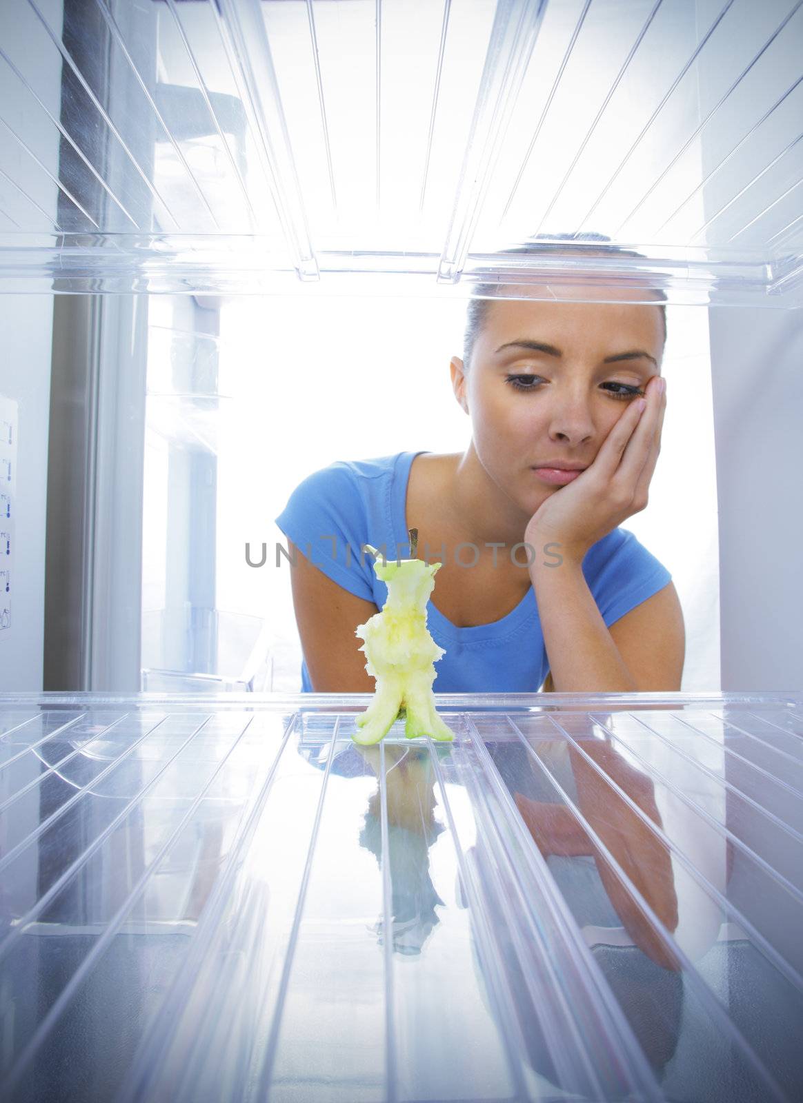 Young woman unhappy to see the empty fridge