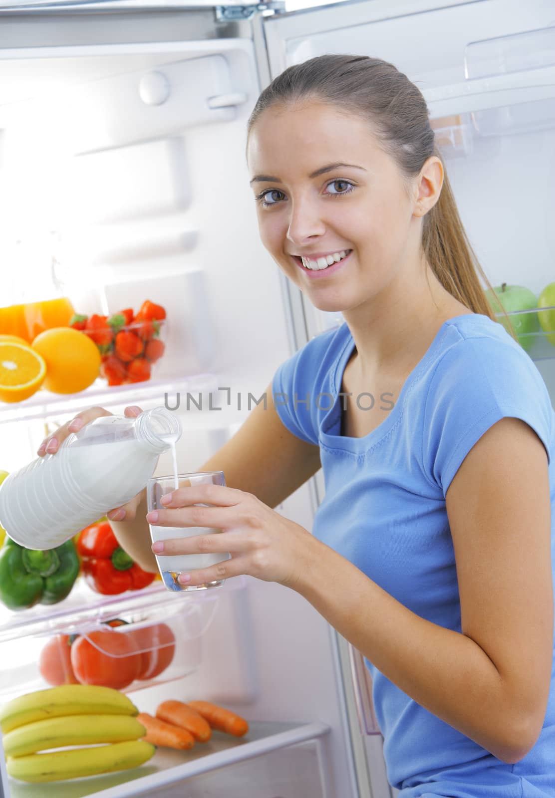 Beautiful woman pour out milk into glass