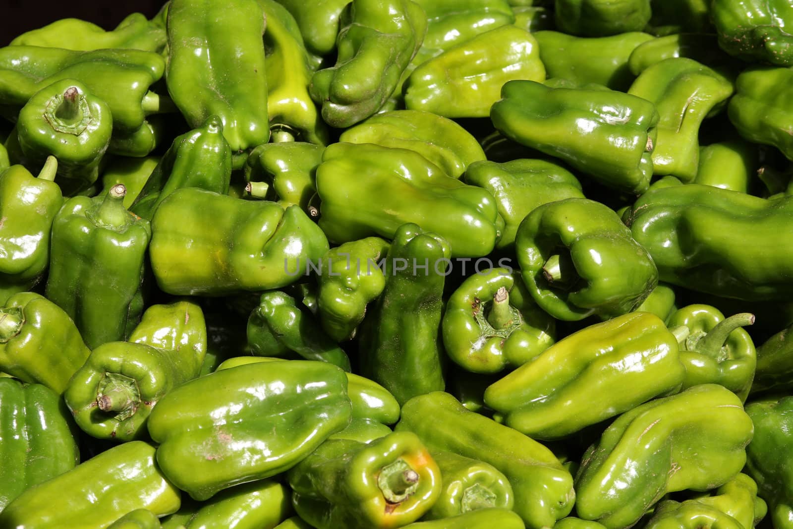Green peppers stacked at a market place. Green grocer's store. Cuba organic produce.