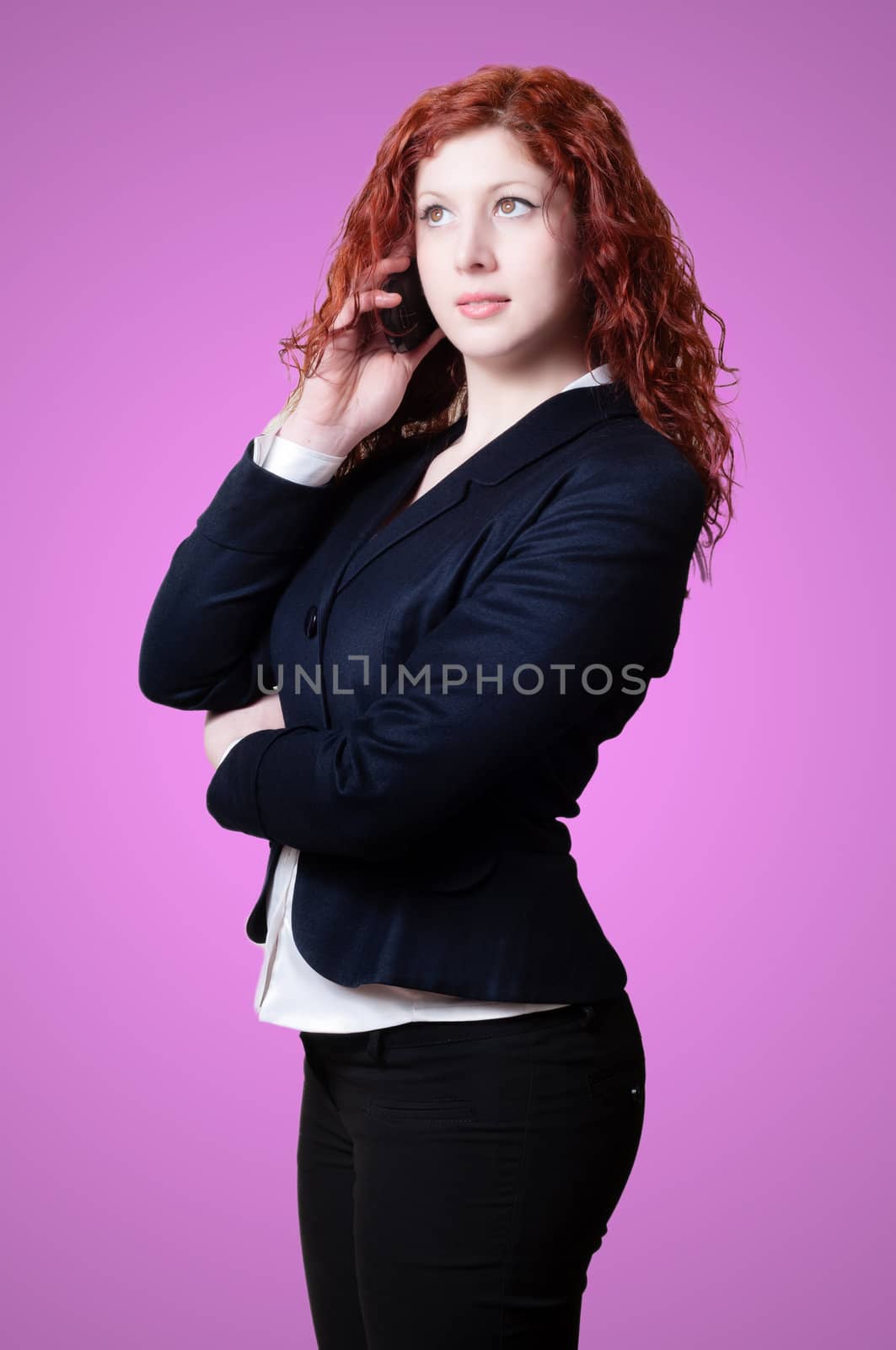 long red hair businesswoman on the phone on pink background
