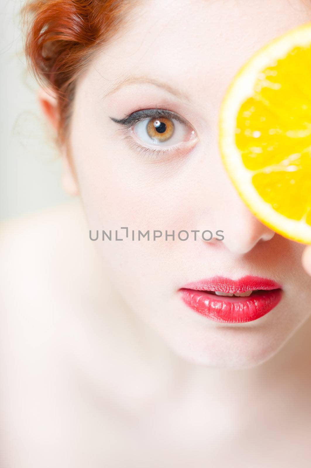 beautiful red hair and lips girl with orange on white background