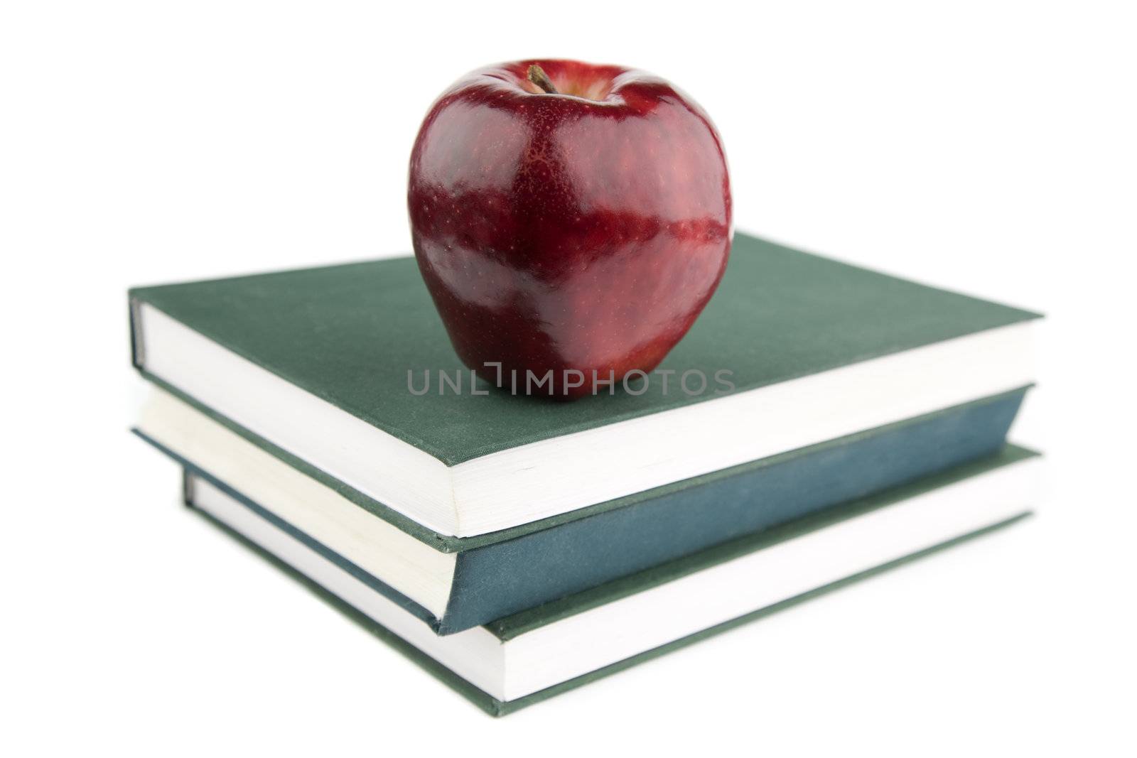 focus point on red apple and nearest part of green textbook
