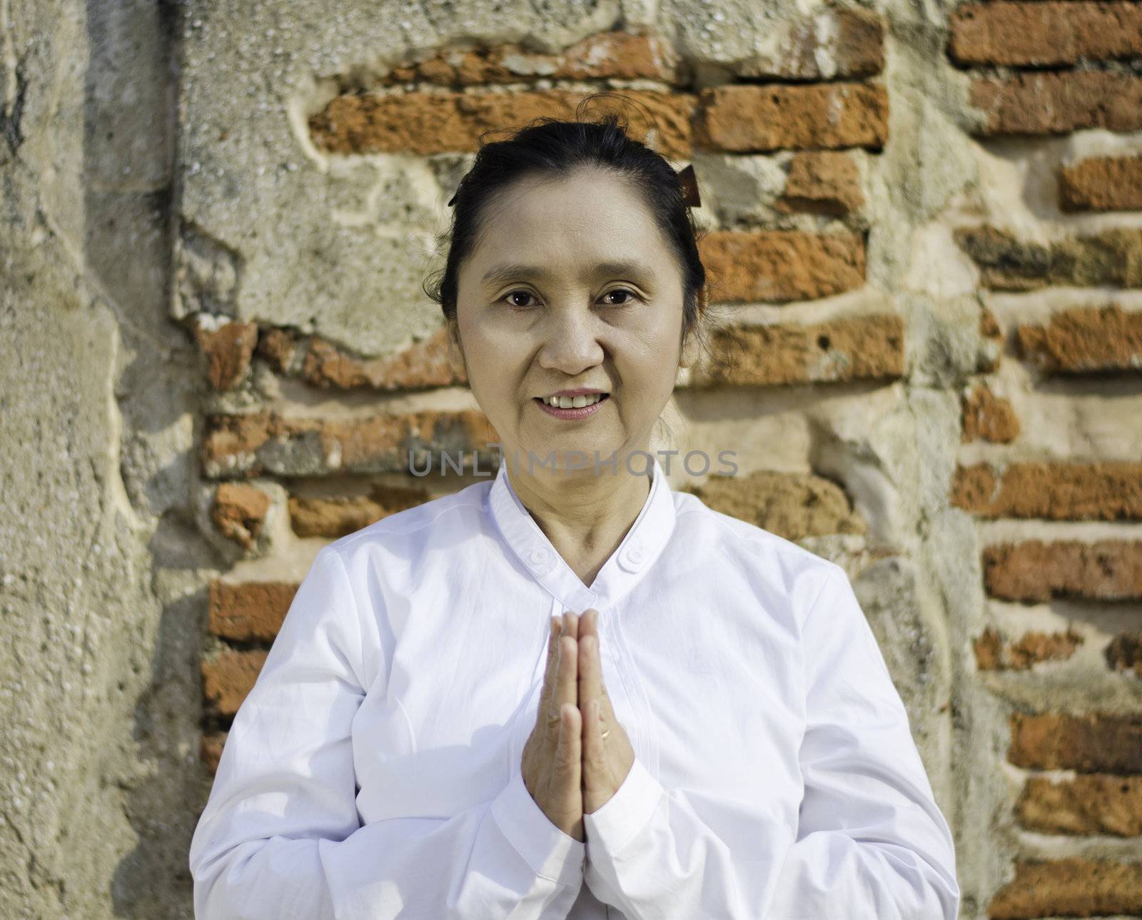 Thai woman in traditional clothes with typical welcome expression 