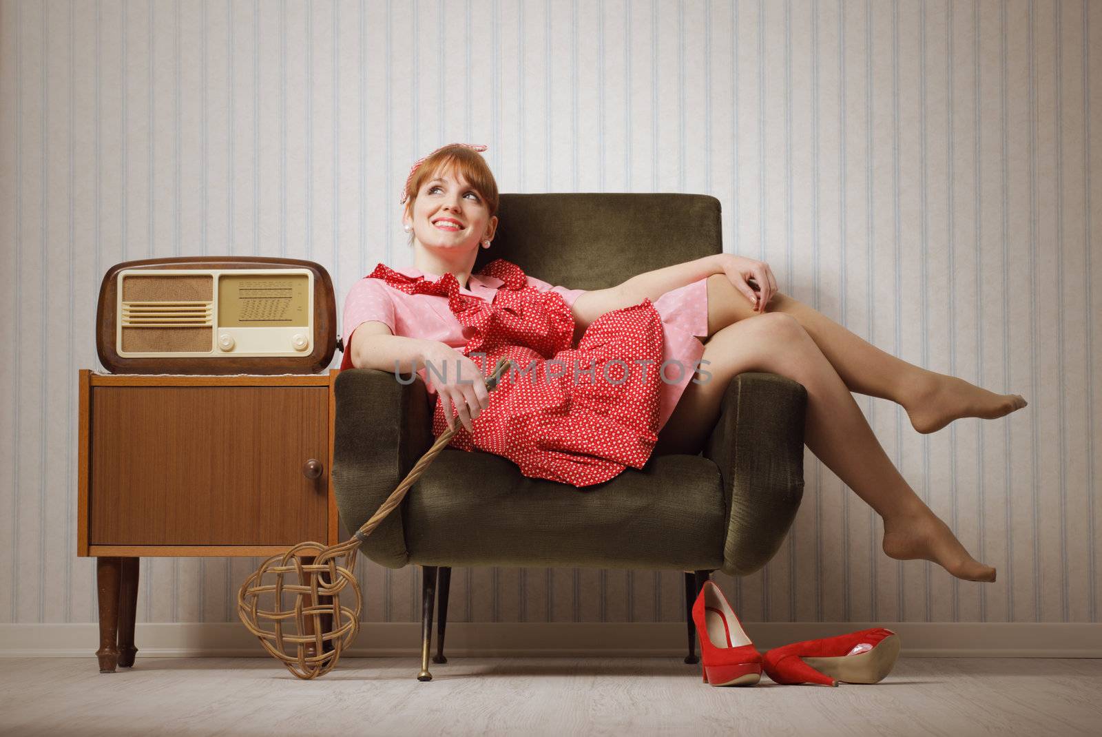 Young retro housewife resting on a chair