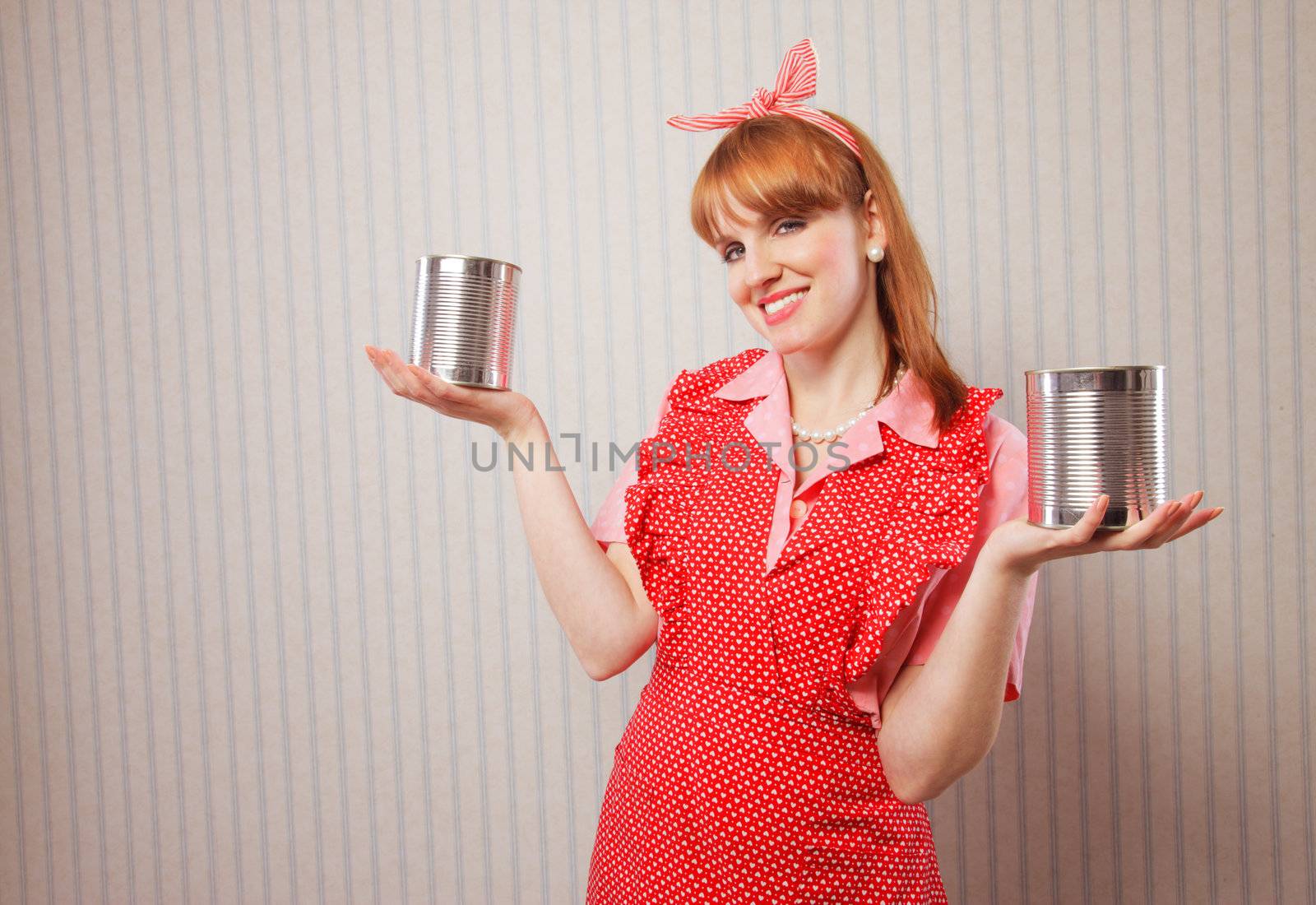 housewife holding two tin food cans