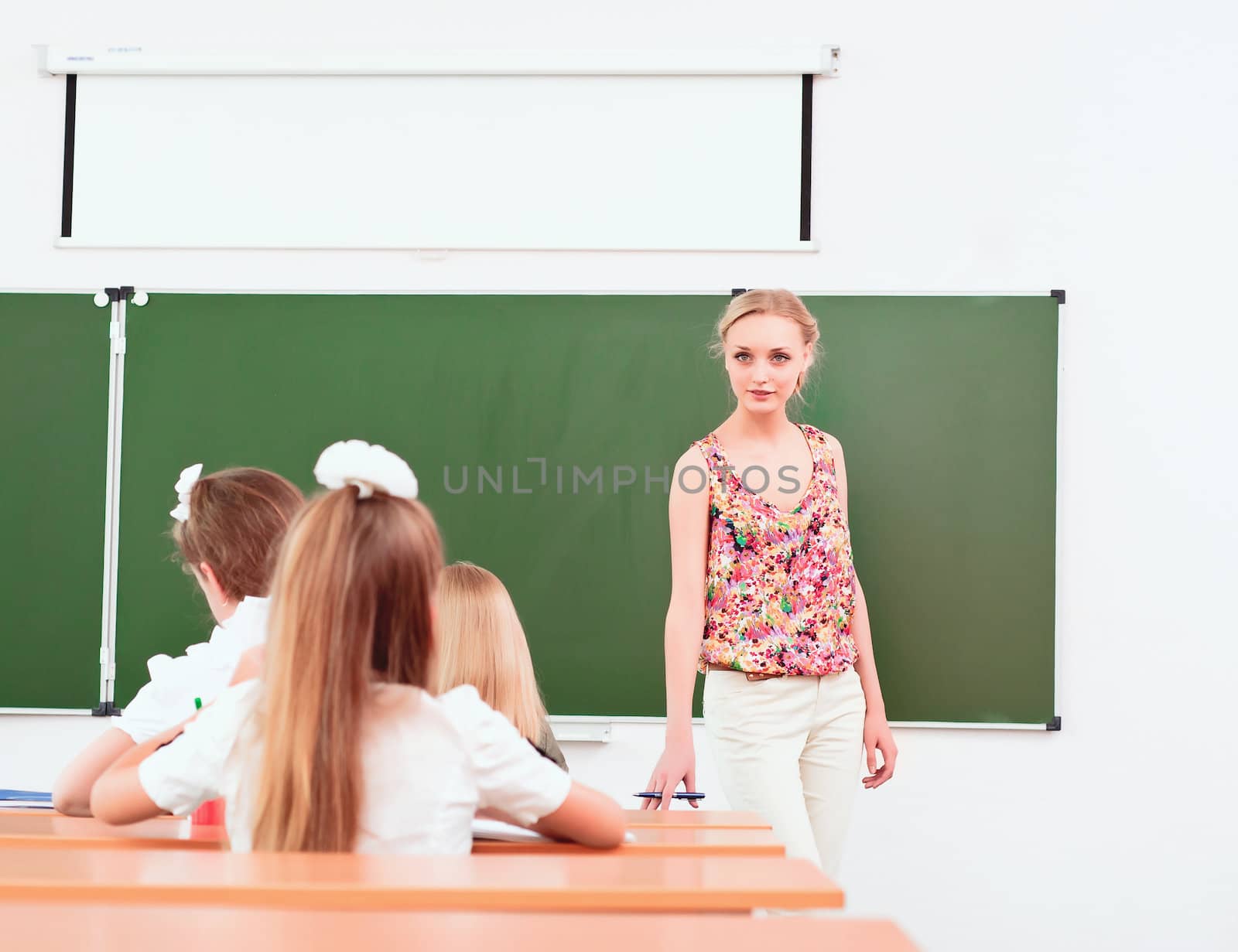 teacher stands in front of students in the class