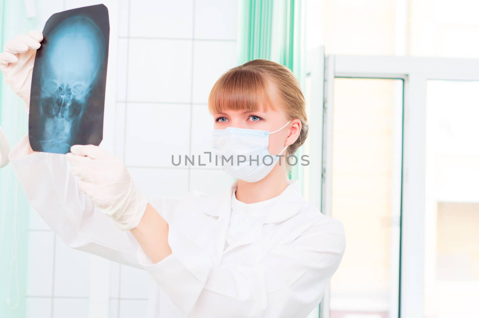 Young woman doctor looks at an X-ray of skull by adam121