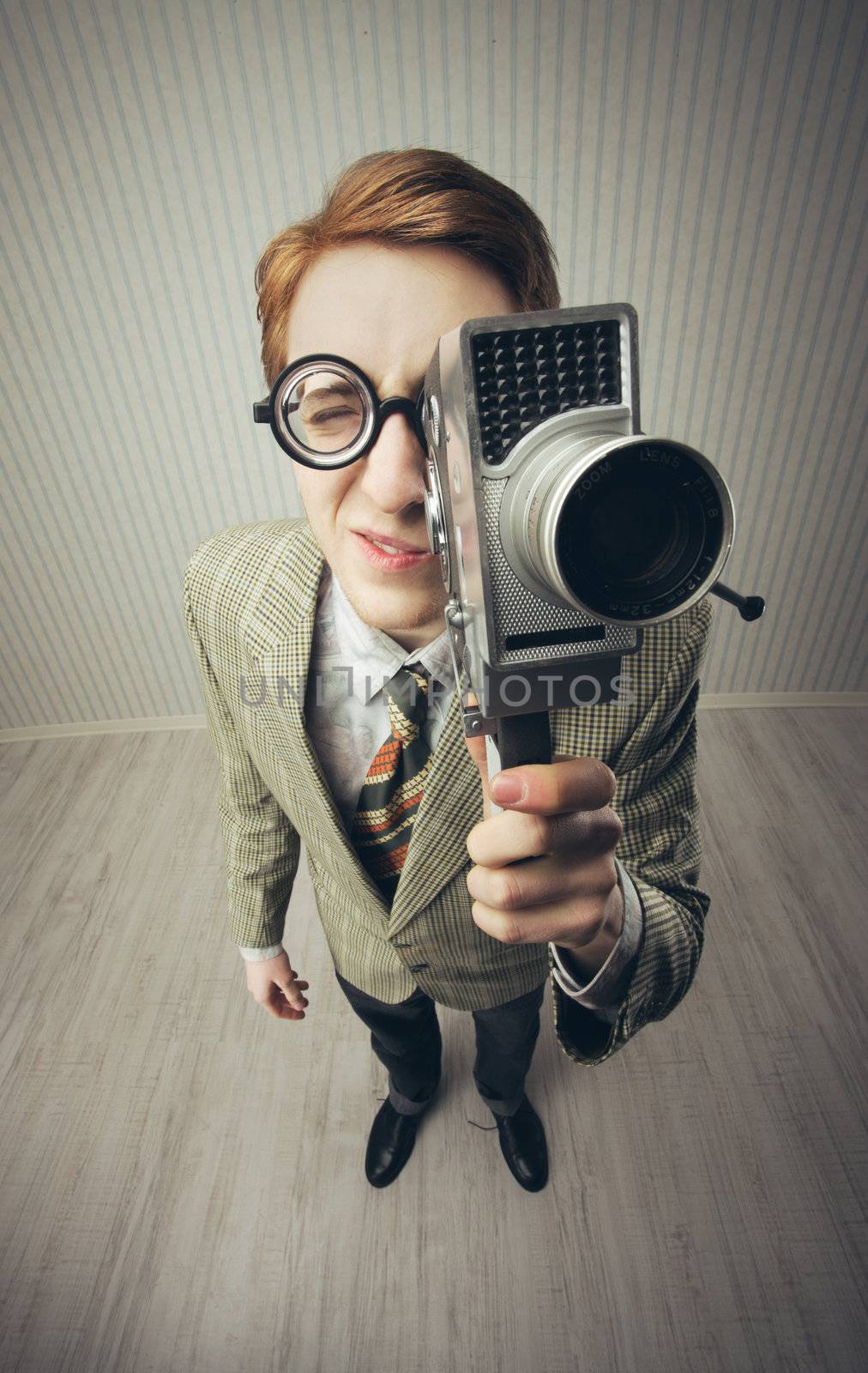 Nerdy young man using old fashioned cine camera