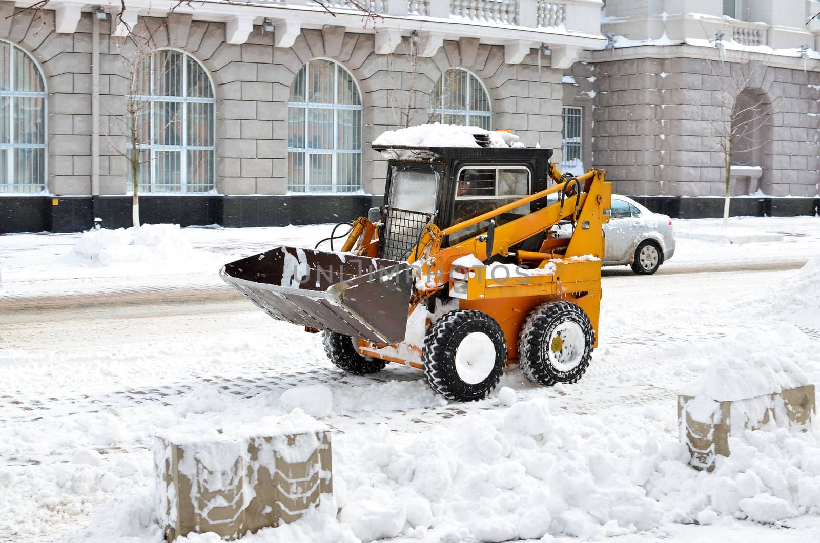 yellow tractor cleaning the snow on a street by DNKSTUDIO