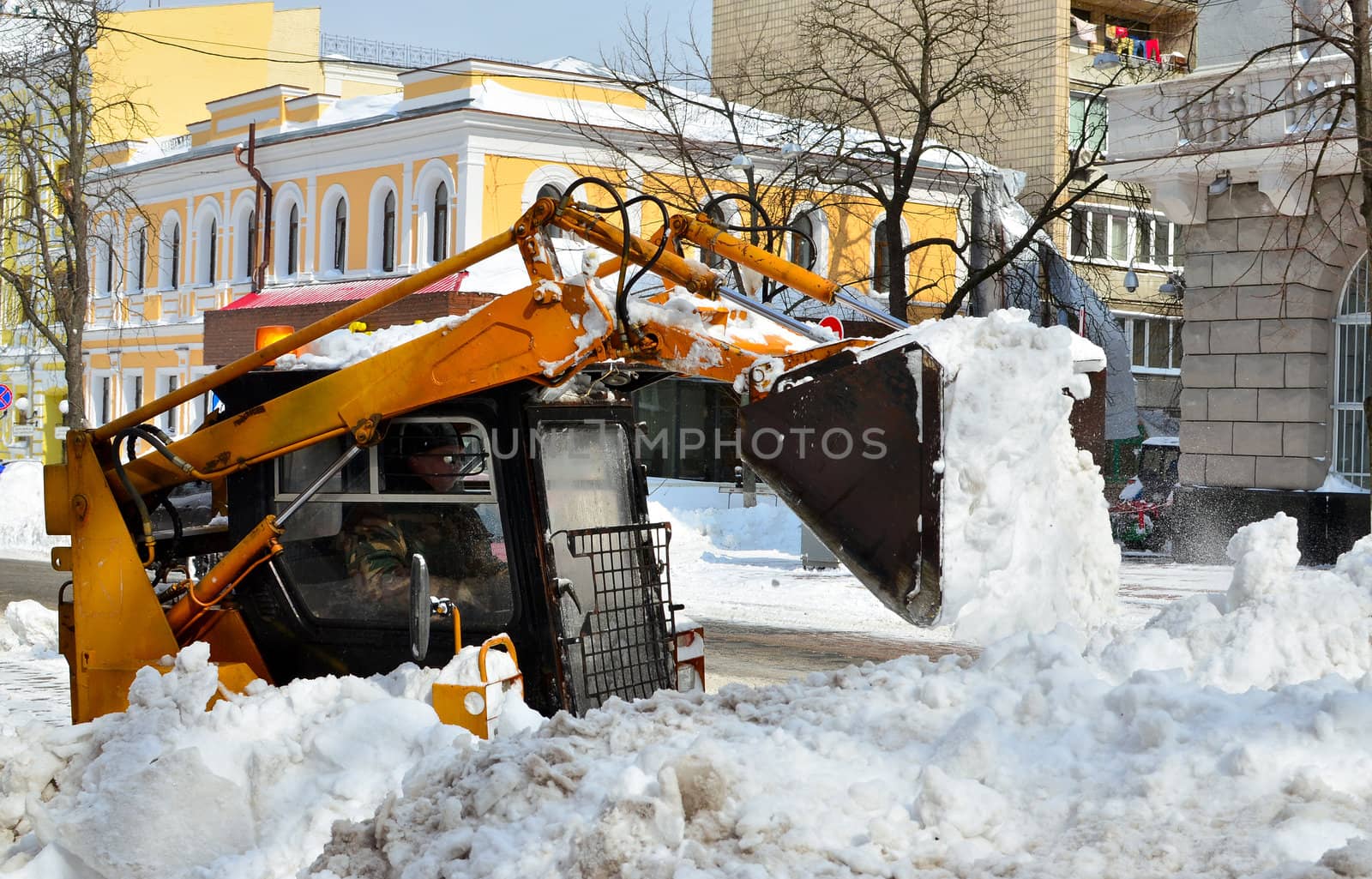 yellow tractor cleaning the snow on a street by DNKSTUDIO