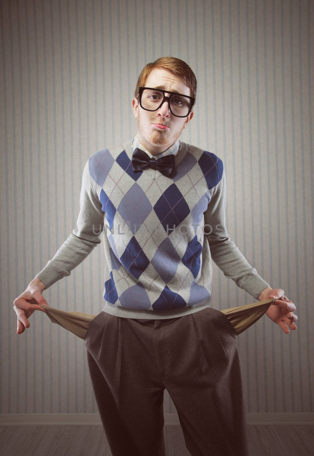 Nerd man stands holding his pockets out showing that he has no money