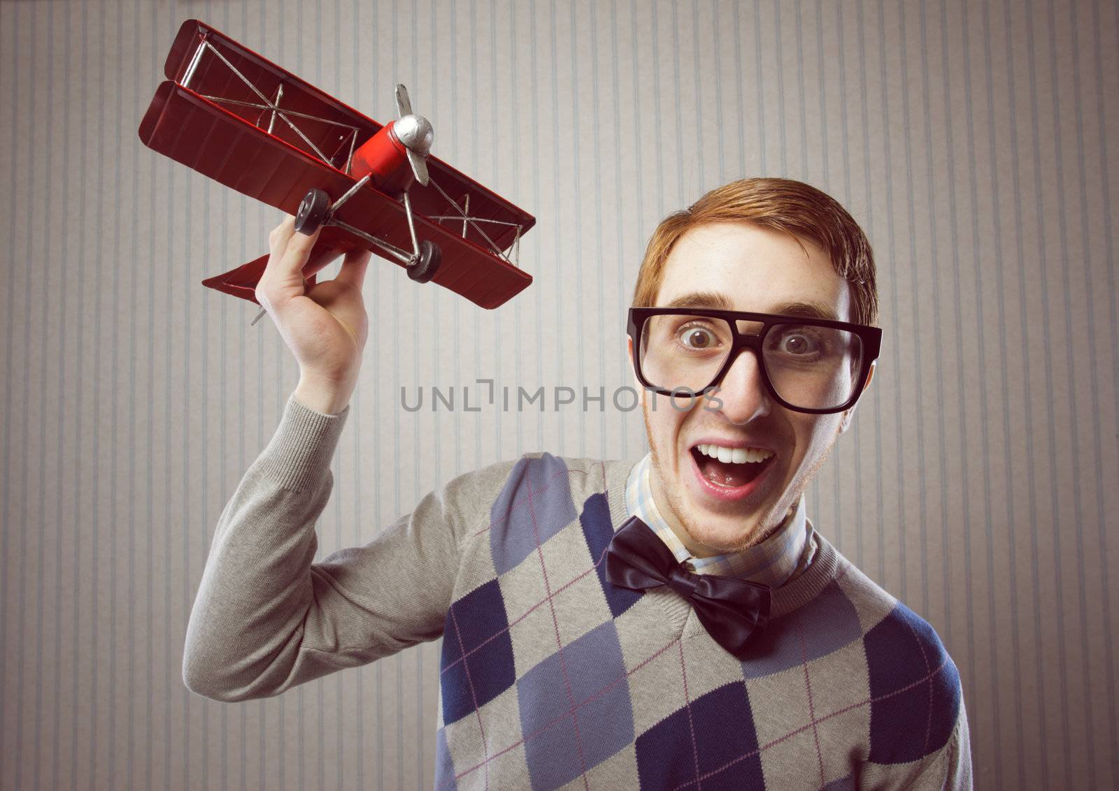 Nerd student playing with a tin airplane