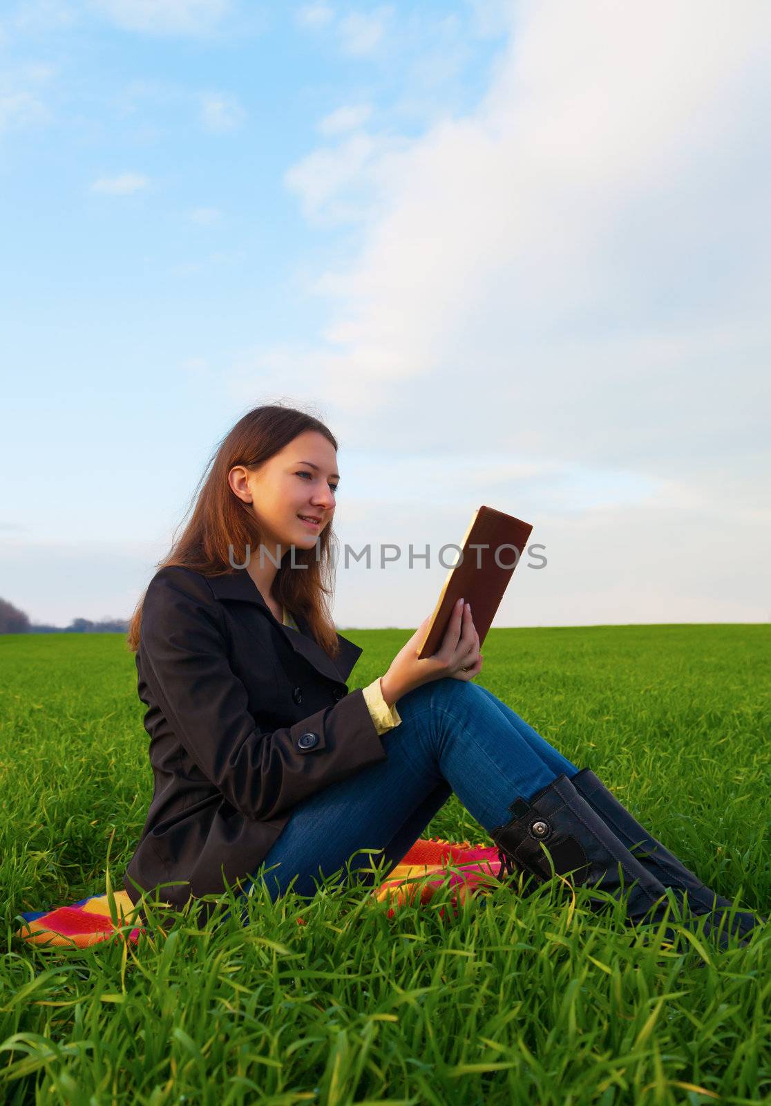 Teen girl reading the Bible outdoors by AndreyKr