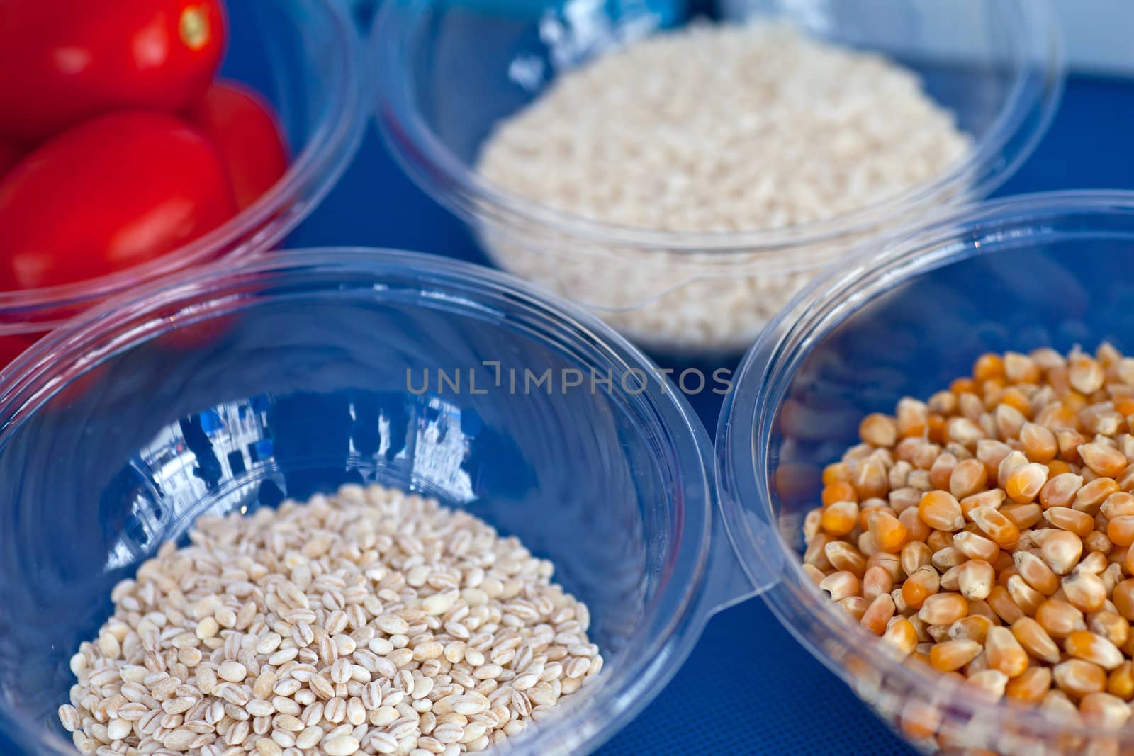 Tomatoes, rice, corn, and wheat berriesinside the glass bowls
