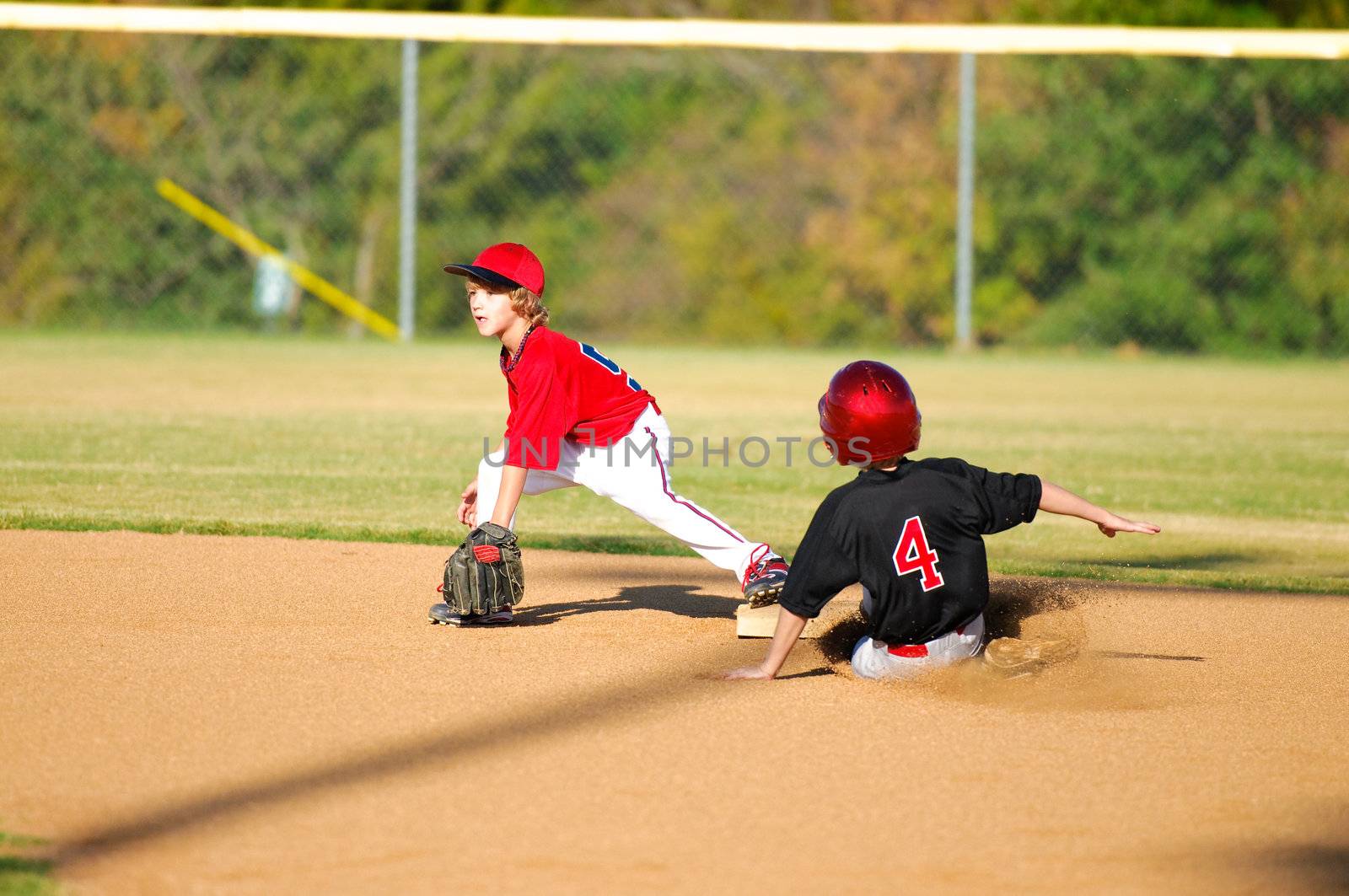 Little league baseball player getting an out at second base.