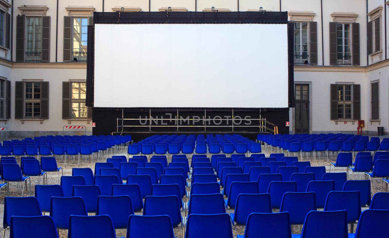 View of screen and Empty blue chairs for outdoor cinema