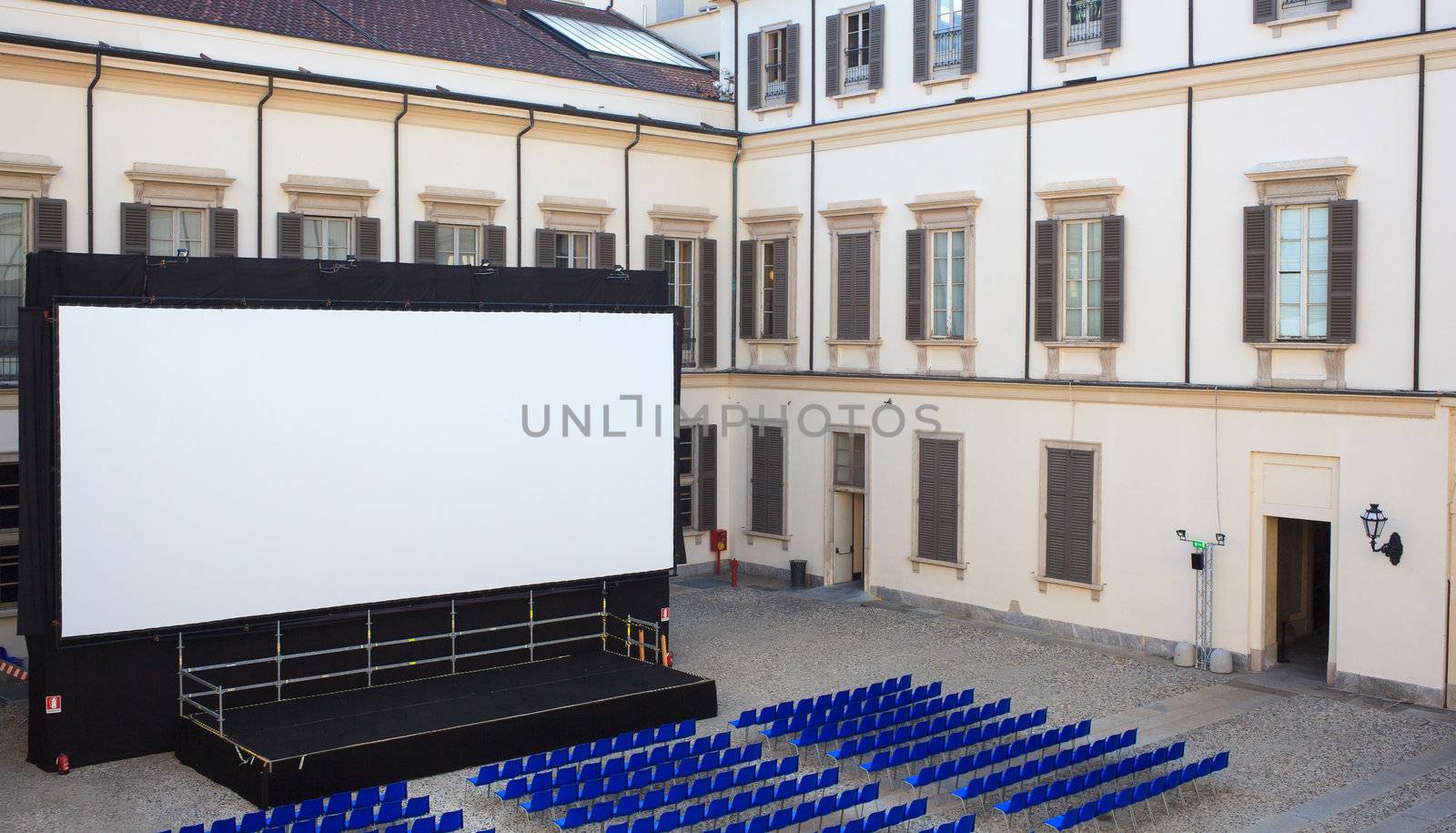 View of screen and Empty blue chairs for outdoor cinema