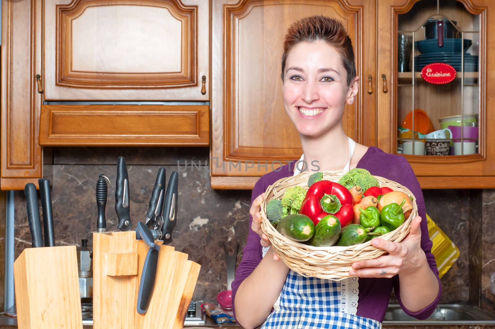beautiful housewife with basket of vegetables in the kitchen