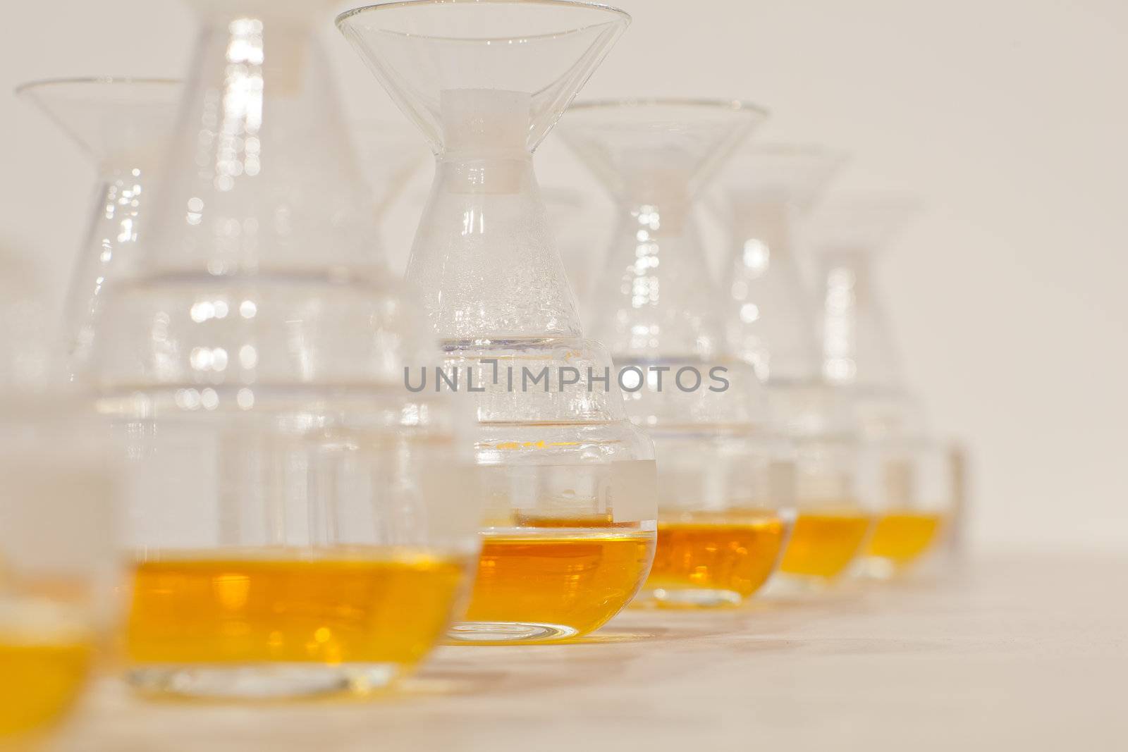 Glass bottles in row with yellow liquid