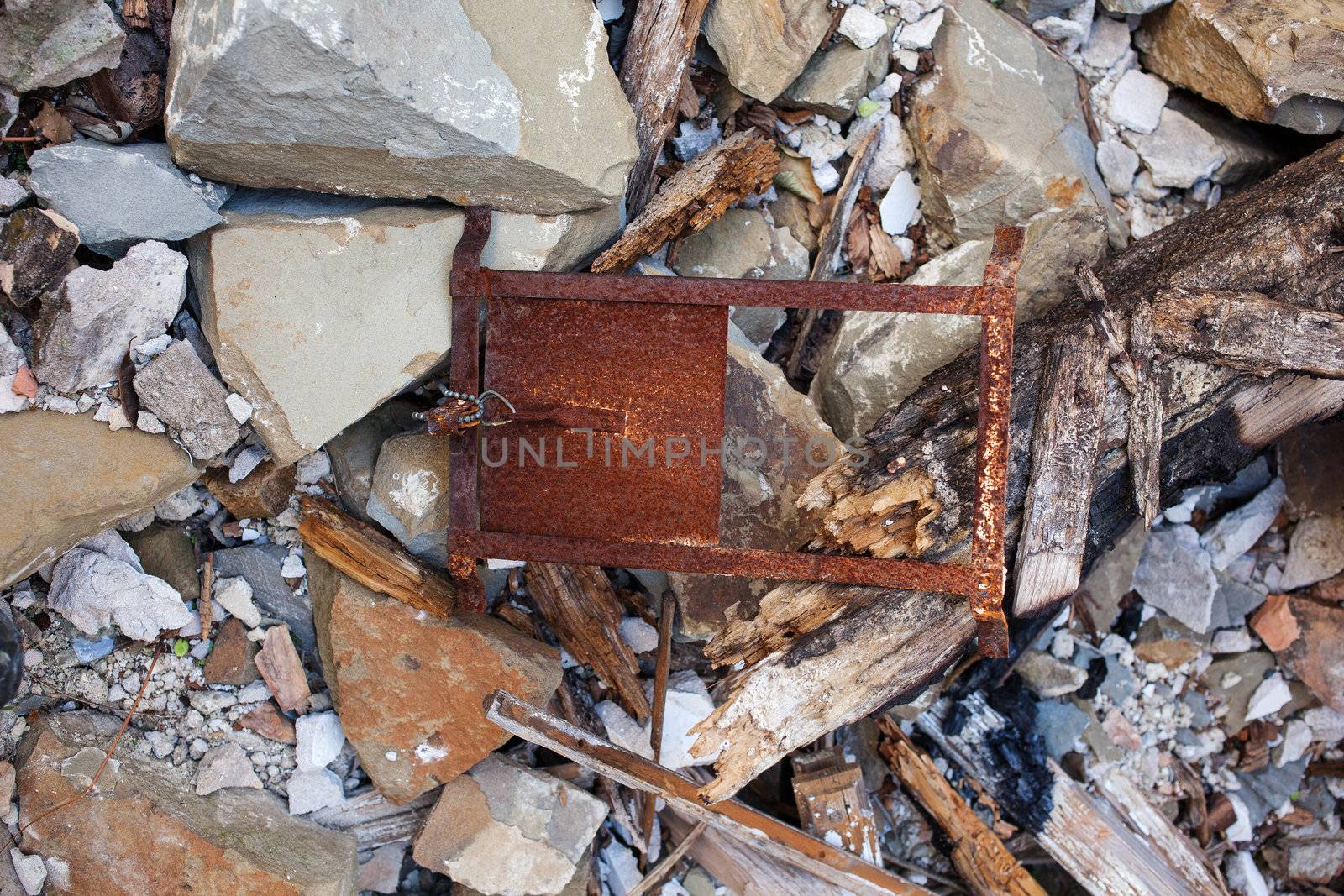View of demolished house with rubble and cracked wall