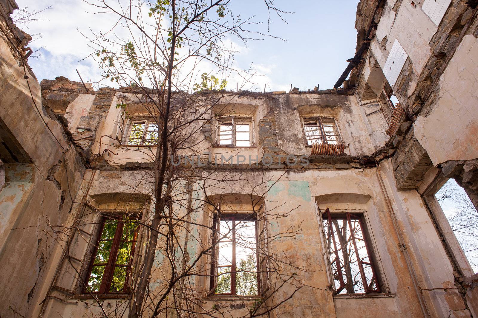 View of demolished house with rubble and cracked wall