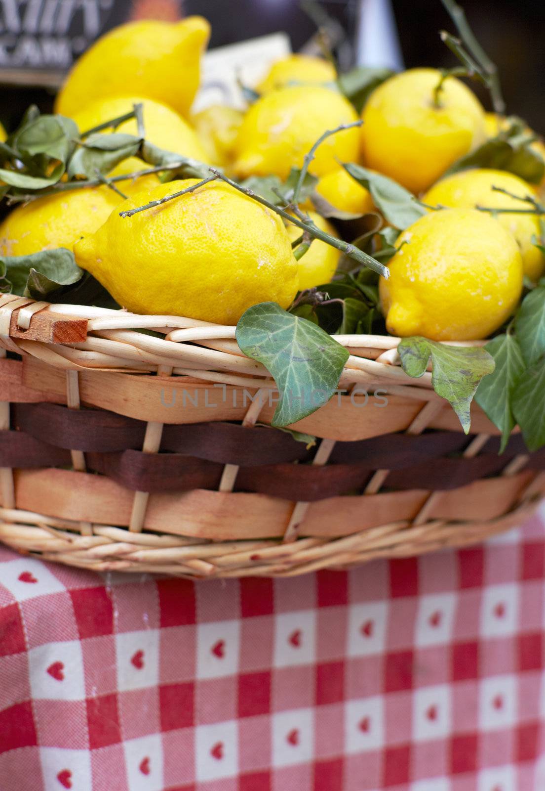 Wicker basket with lemons by bepsimage