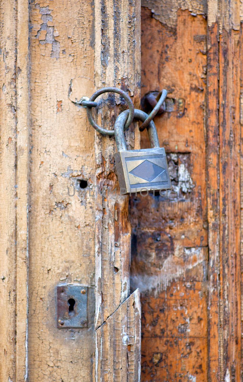 Old door with padlock by bepsimage