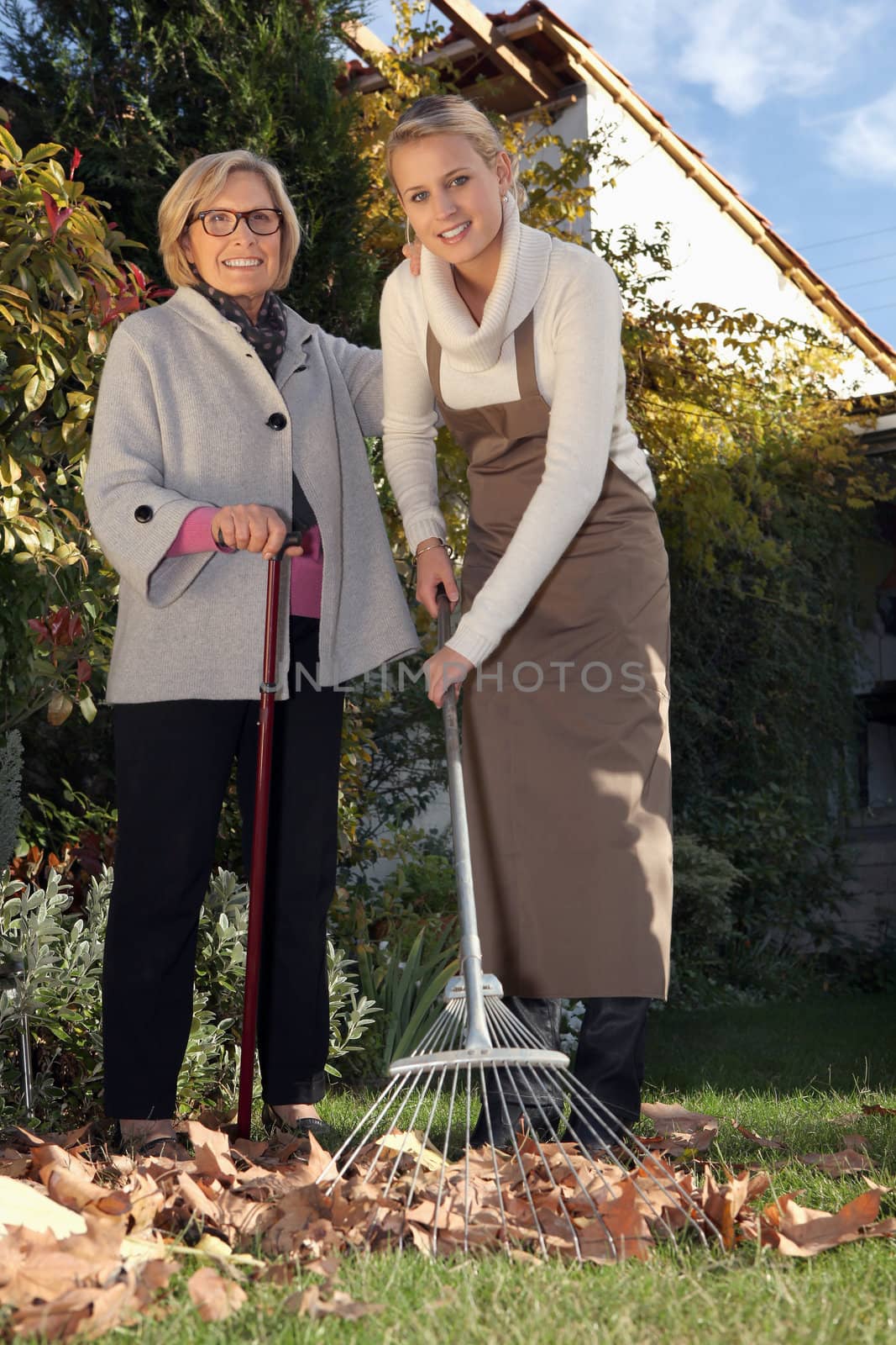 Young woman helping a senior with her garden