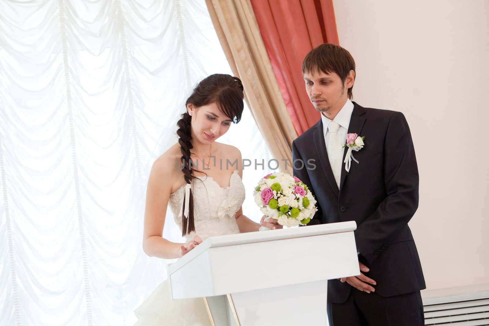 bride and groom signing a wedding document by vsurkov