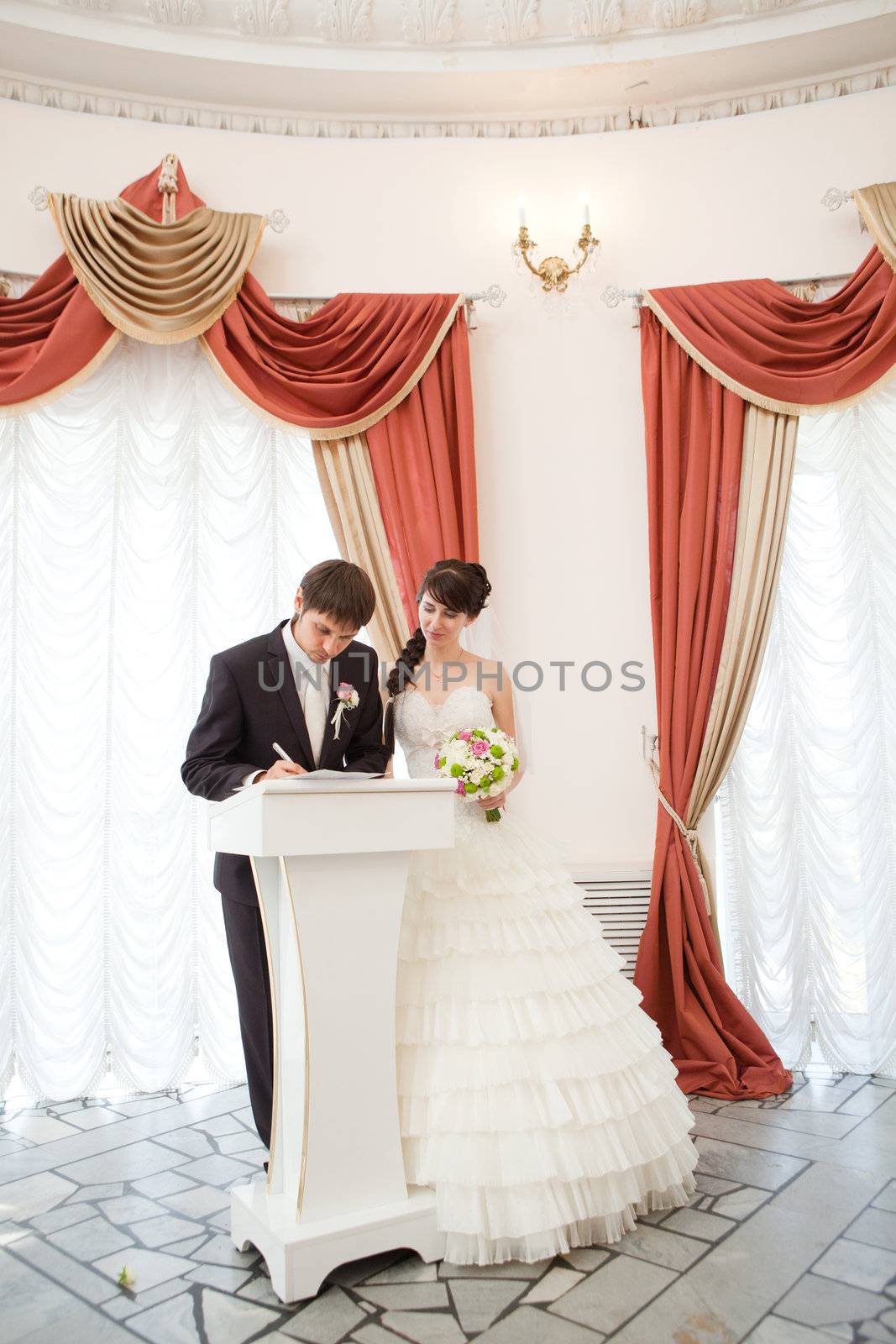 bride and groom signing a wedding document by vsurkov