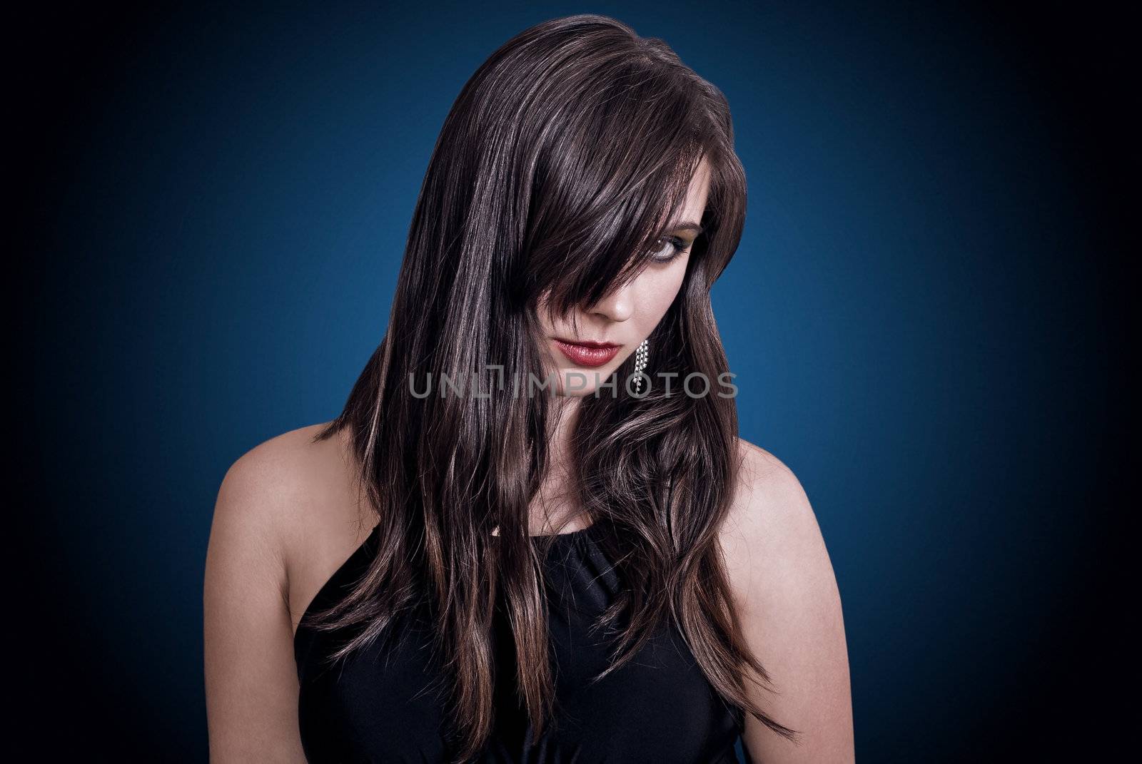 Closeup portrait beautiful brunette in studio on blue background.