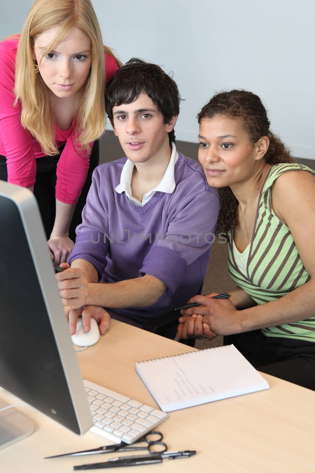 Teenagers looking at a computer screen by phovoir