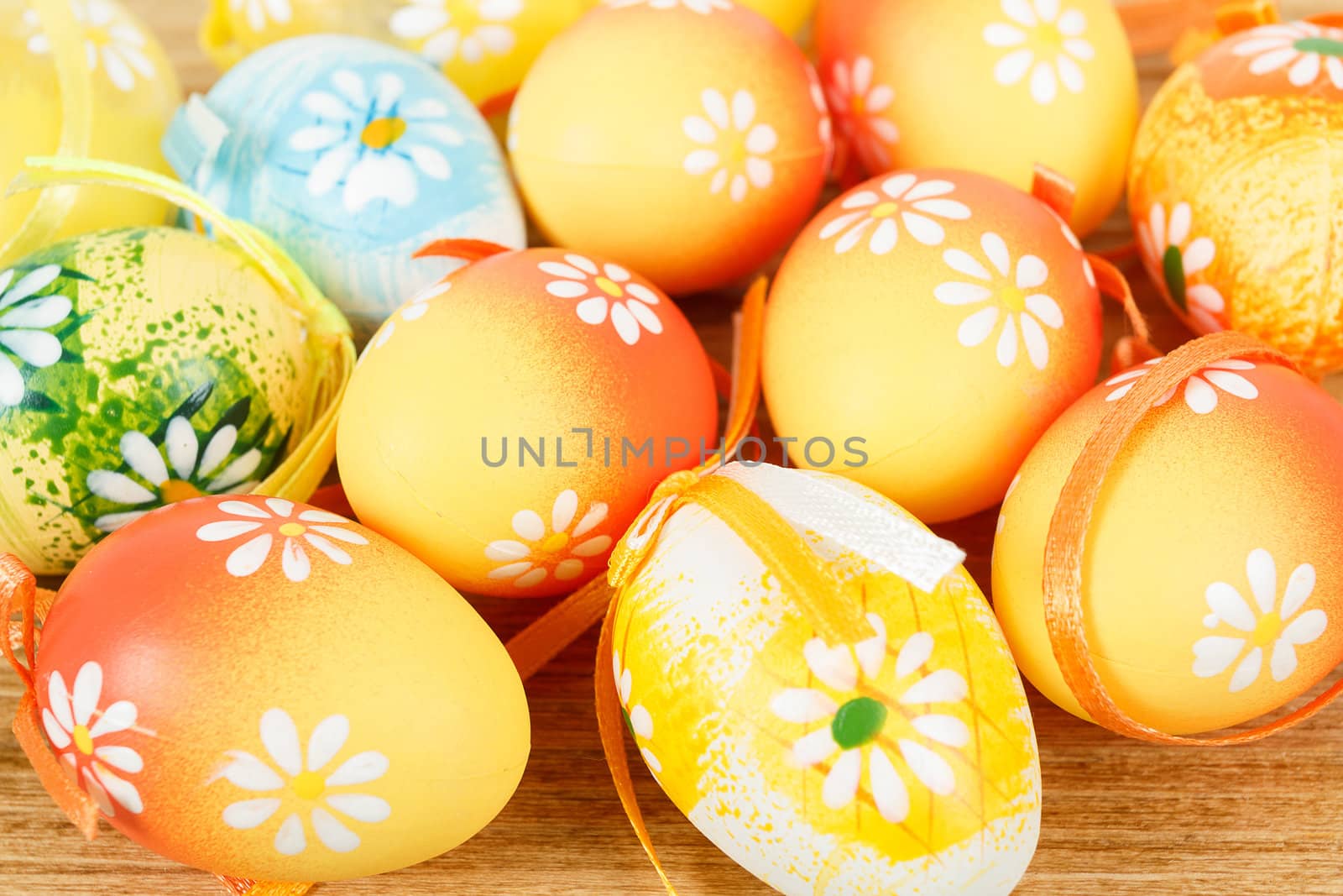 Bright color easter eggs with bows on wooden desk