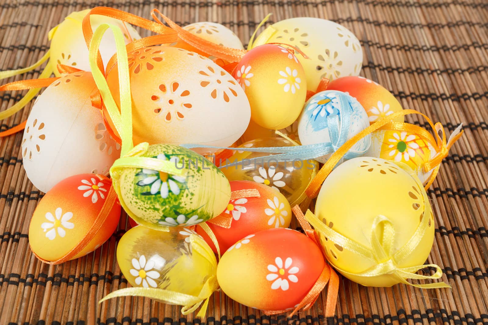 Bright color easter eggs with bows on wooden desk