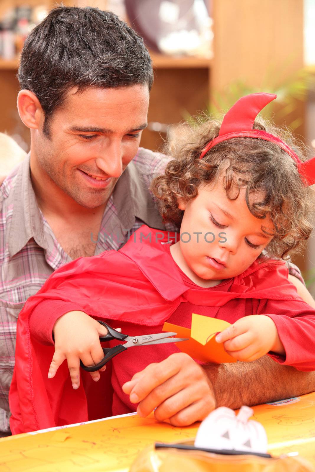Child cutting paper with Dad by phovoir