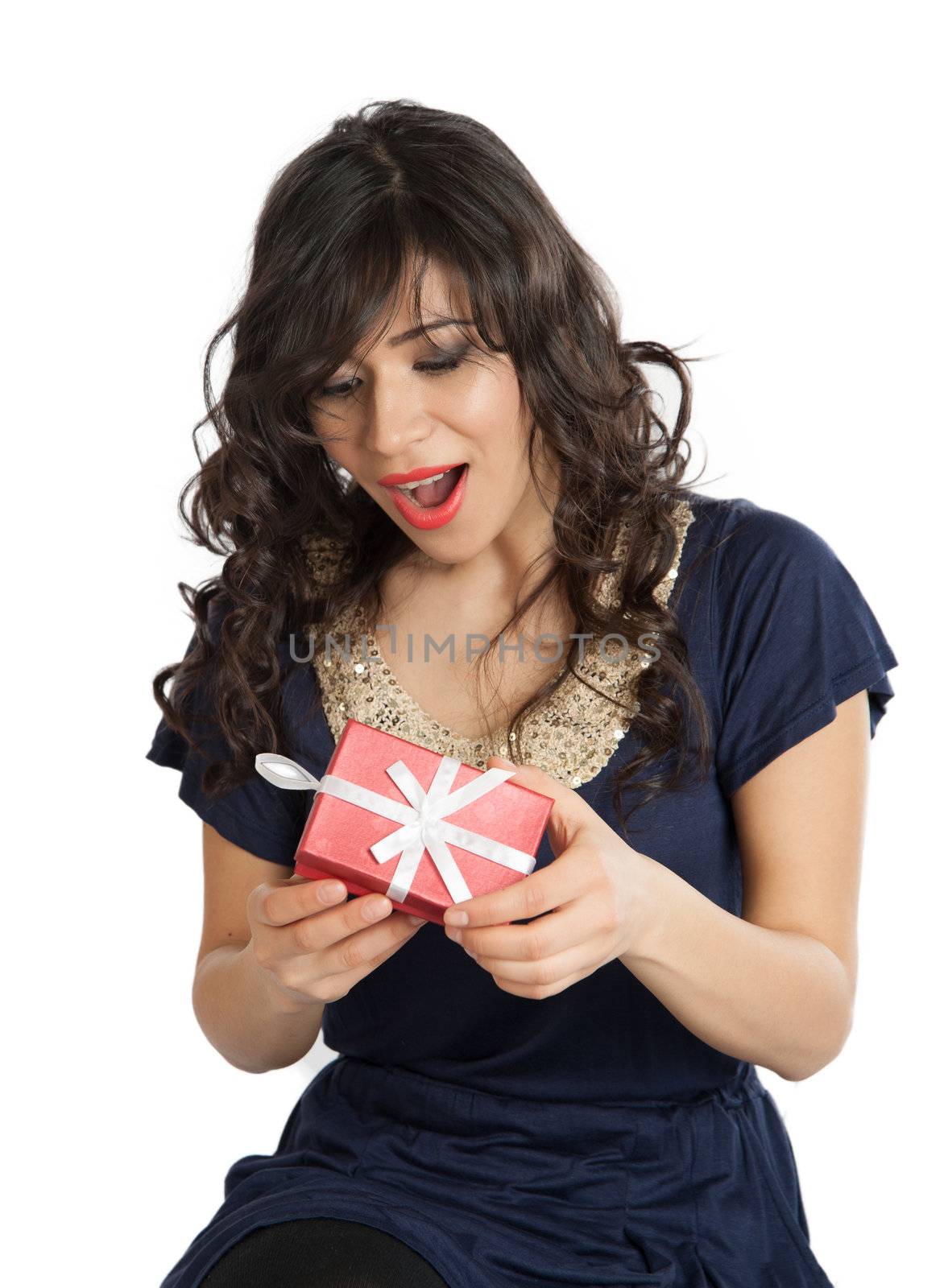 Brunette in a blue dress opens gift joyfully