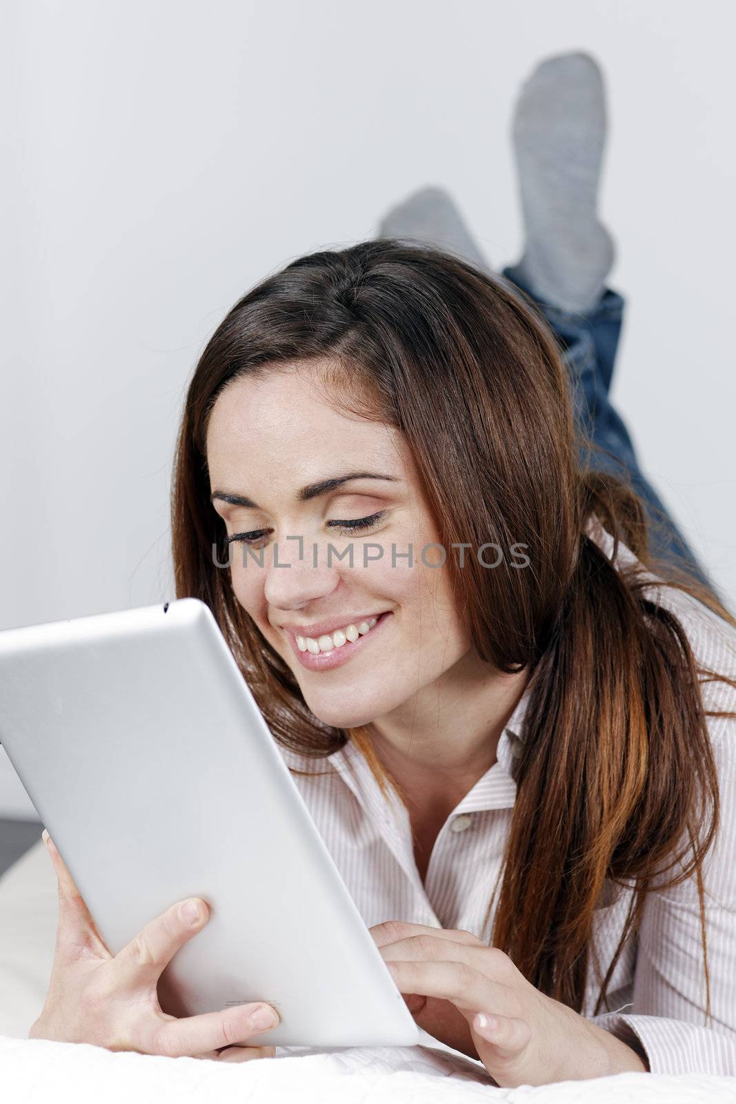 young smiling woman on sofa with tablet 