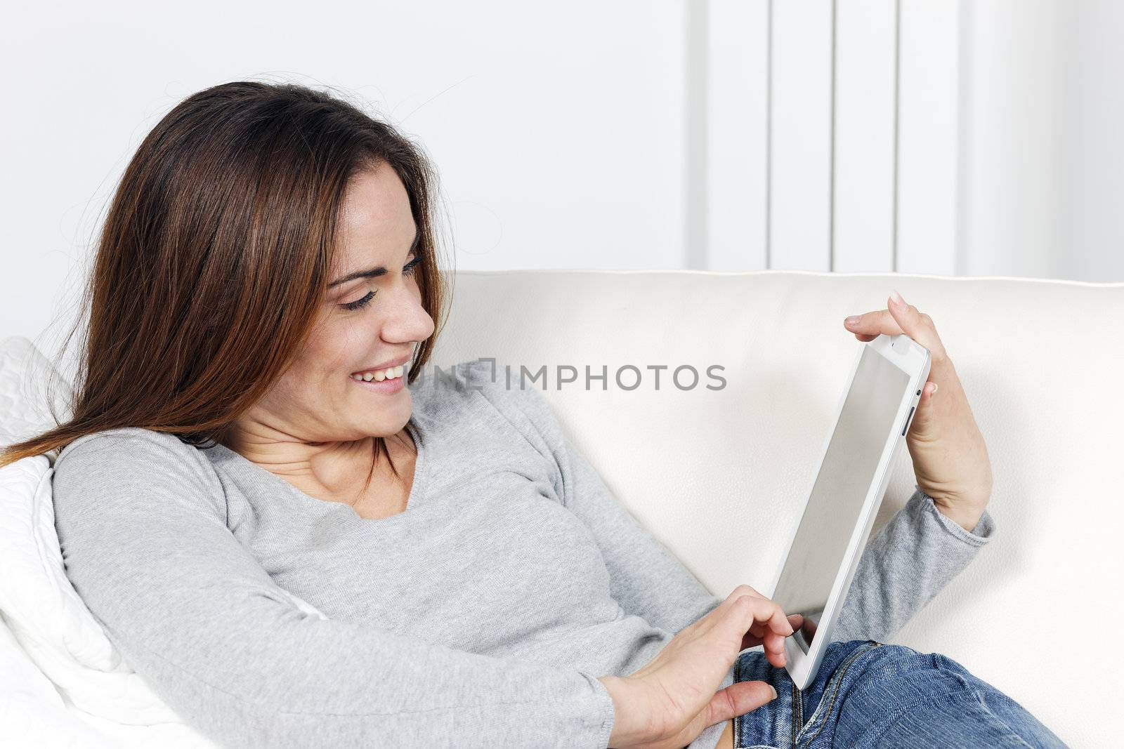 young woman with tablet on sofa at home