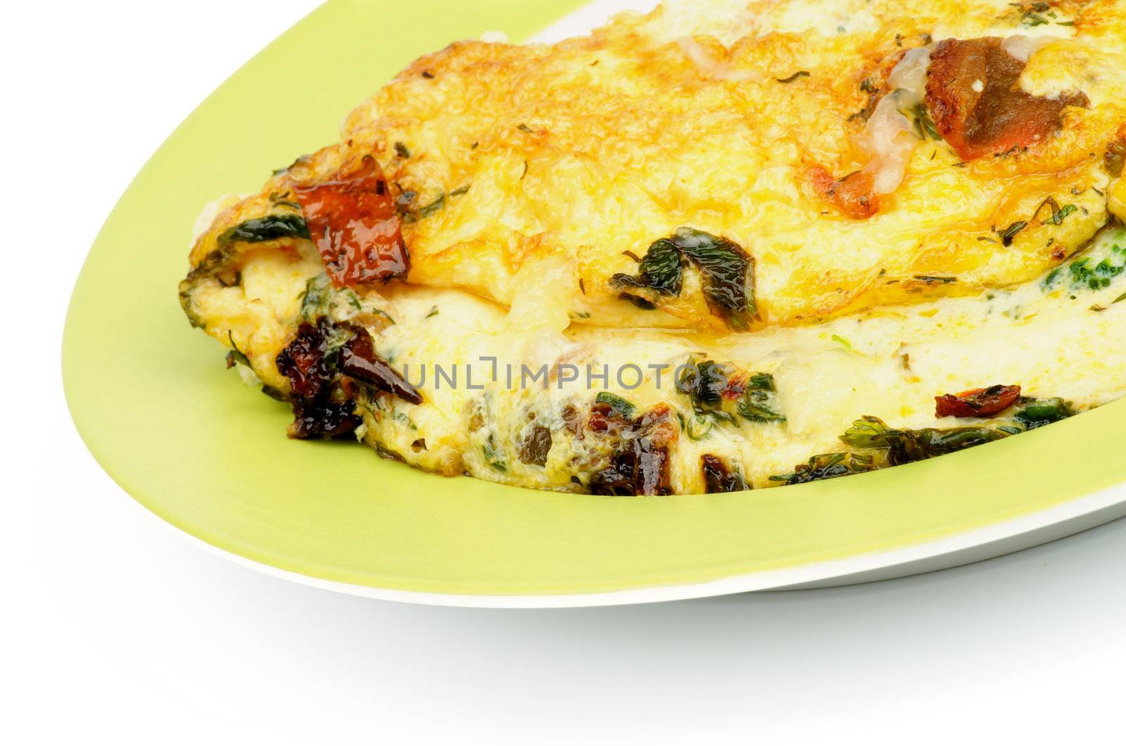 Delicious Omelet with Tomatoes, Parsley, Leek and Dill on Green Plate closeup