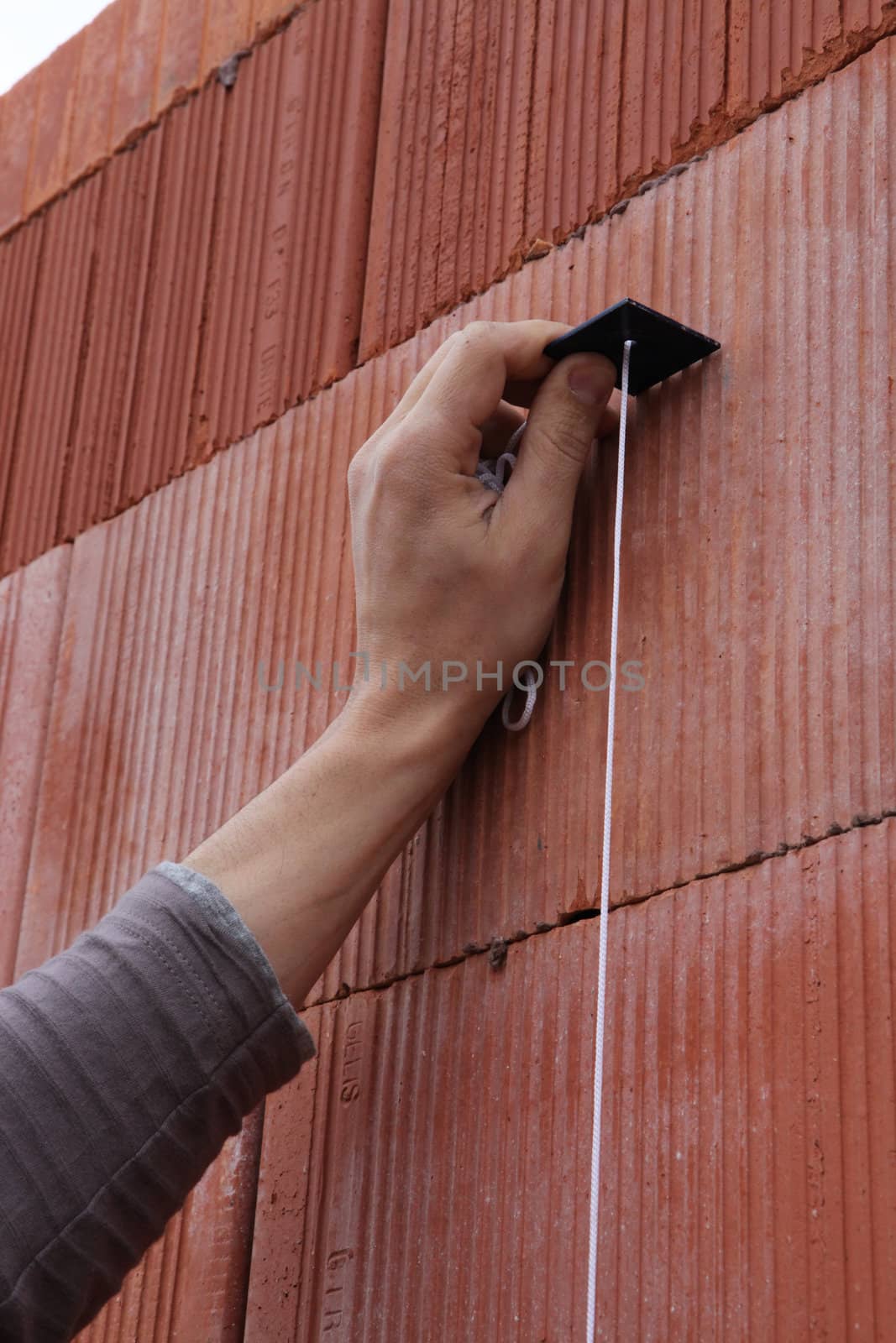 Mason checking wall is straight by phovoir