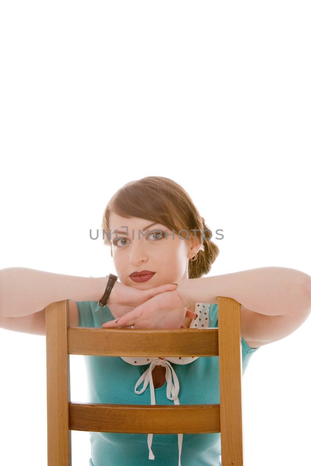 the beautiful young girl sits on a wooden 
chair, a portrait 
on a white background