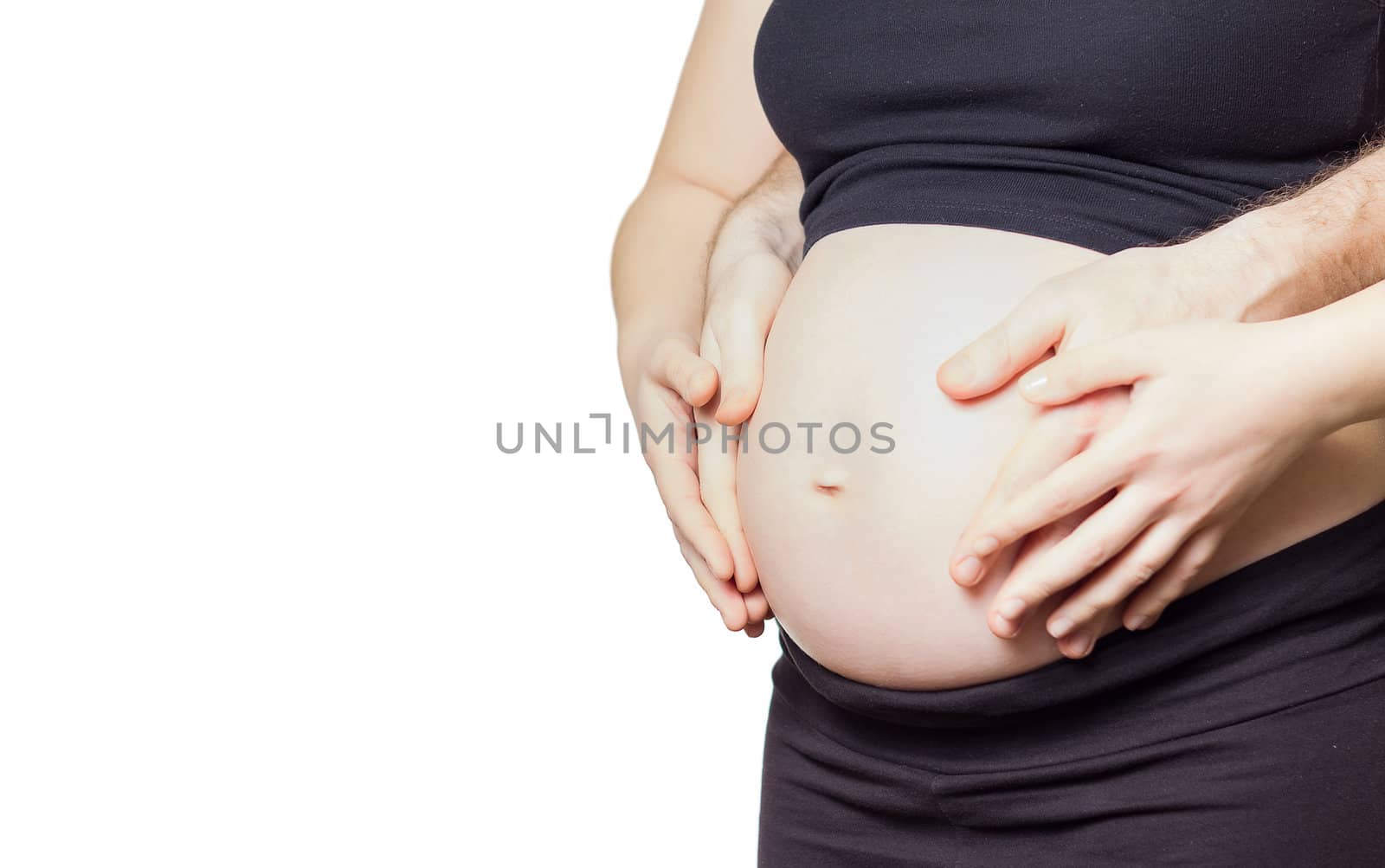 Closeup of pregnant woman touching her belly with hands and her husband too, isolated on white background