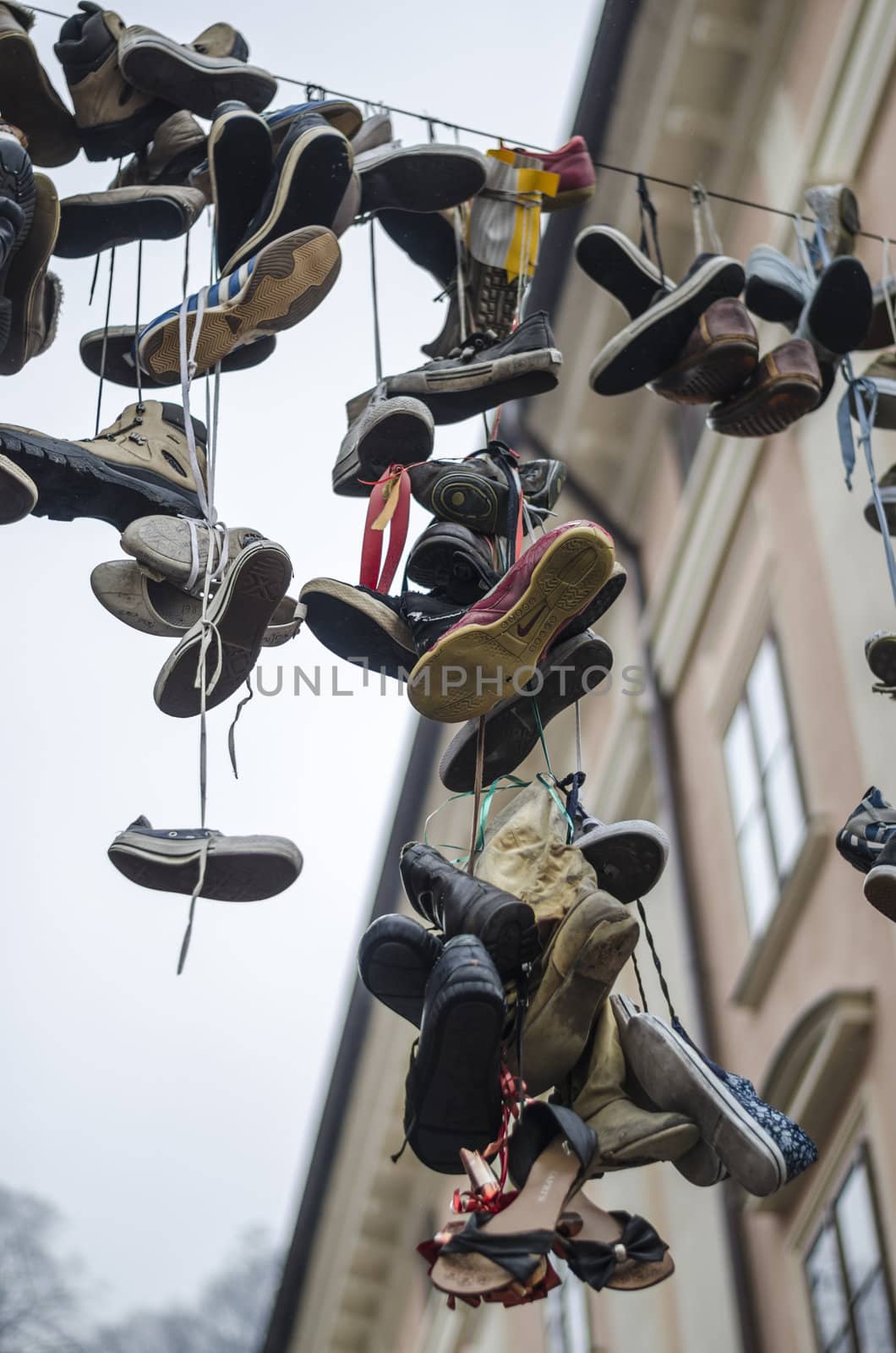 LJUBLJANA, SLOVENIA - MARCH 6: Artistic instalation of worn out shoes hanging from a cable above street, March 6, 2013 in Ljubljana, Slovenia. 