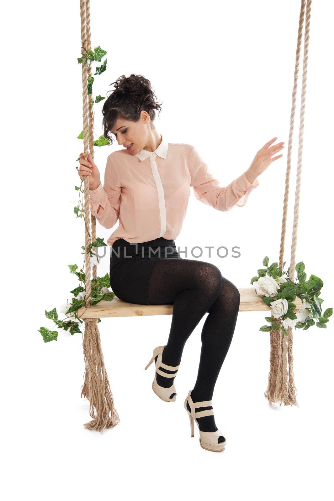 A woman in a pink blouse sitting on a swing isolated white background
