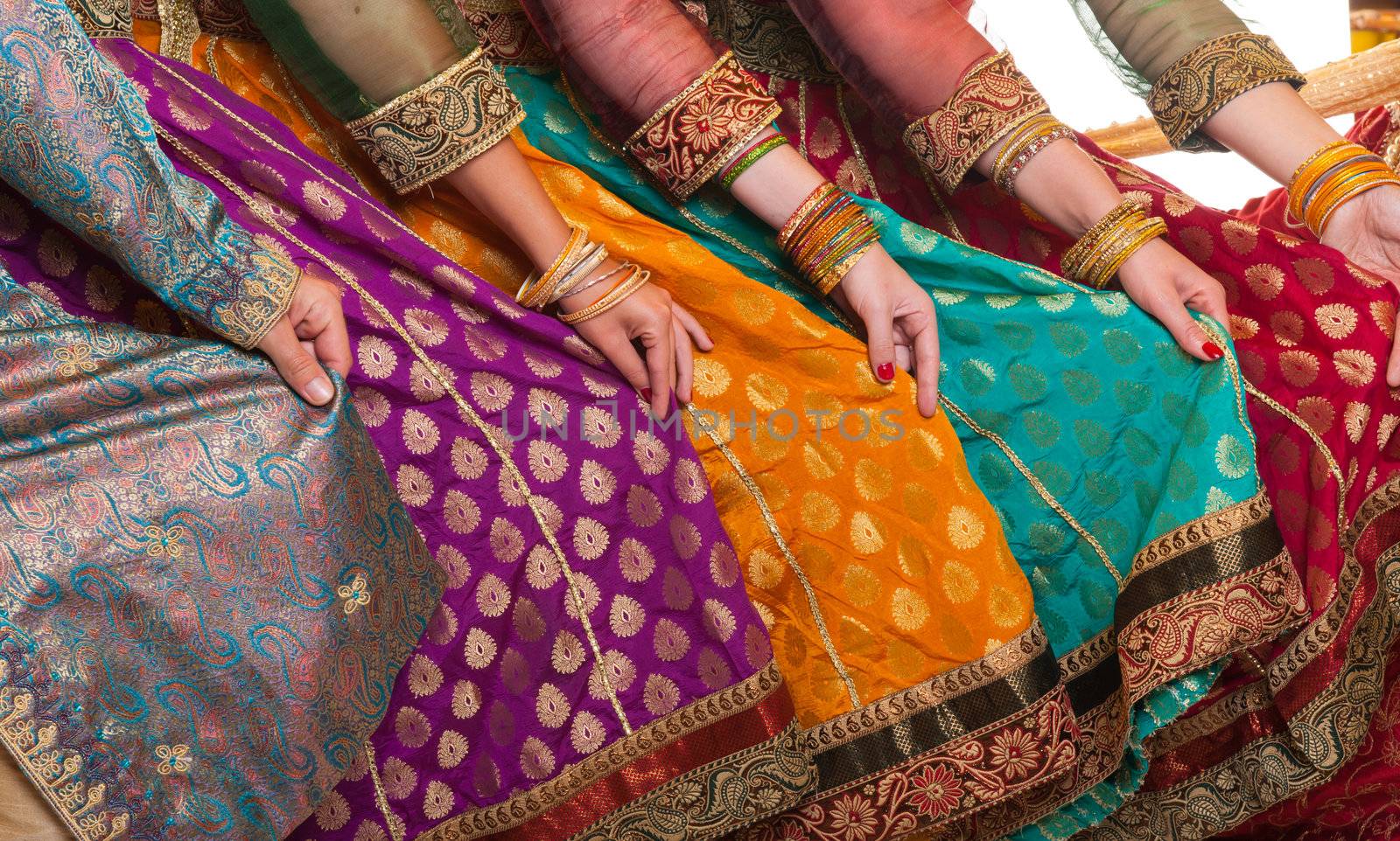 Bollywood dancers are holding their vivid costumes. Hands are in a row