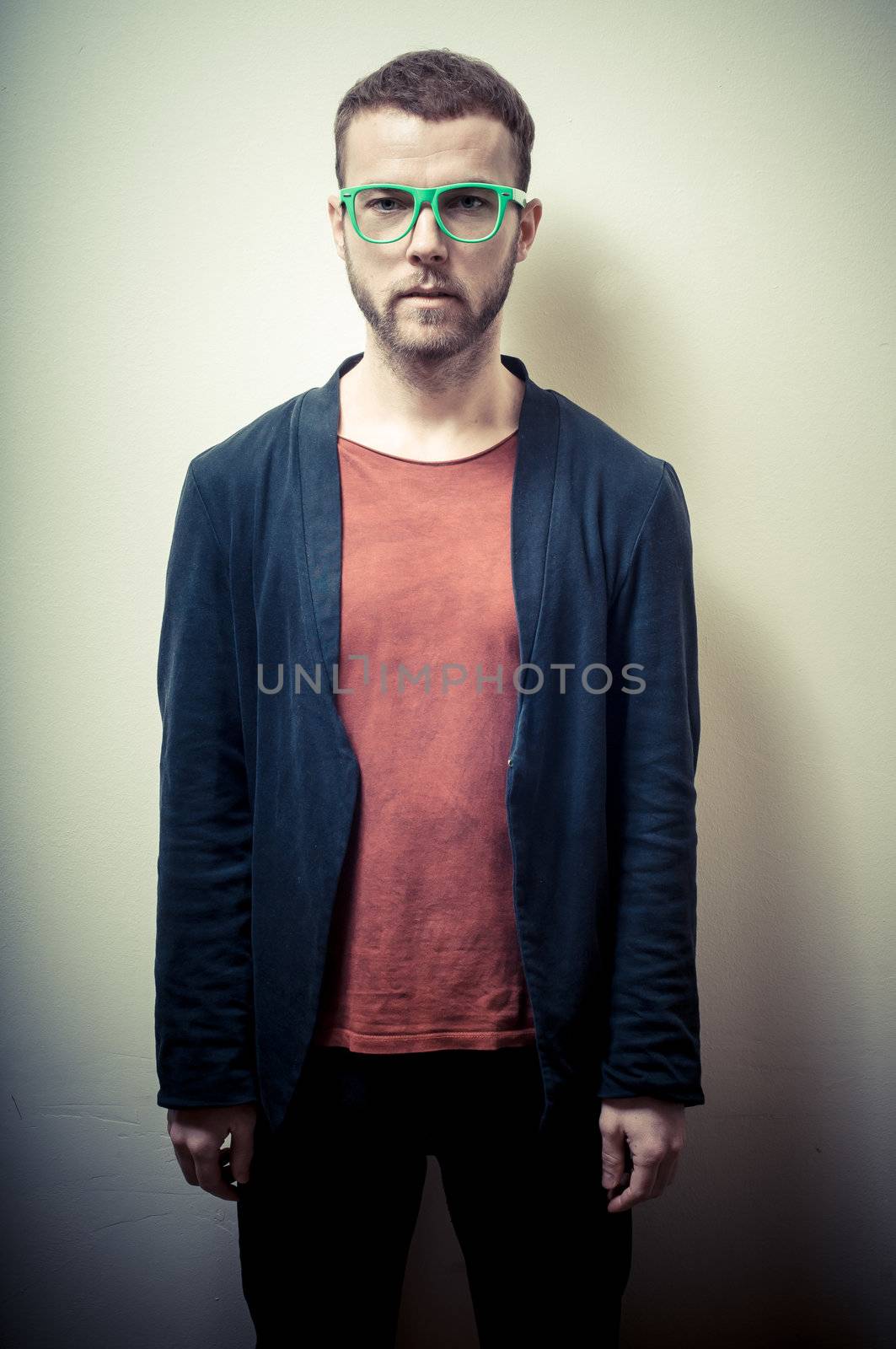 vintage portrait of fashion guy with green eyeglasses on gray background