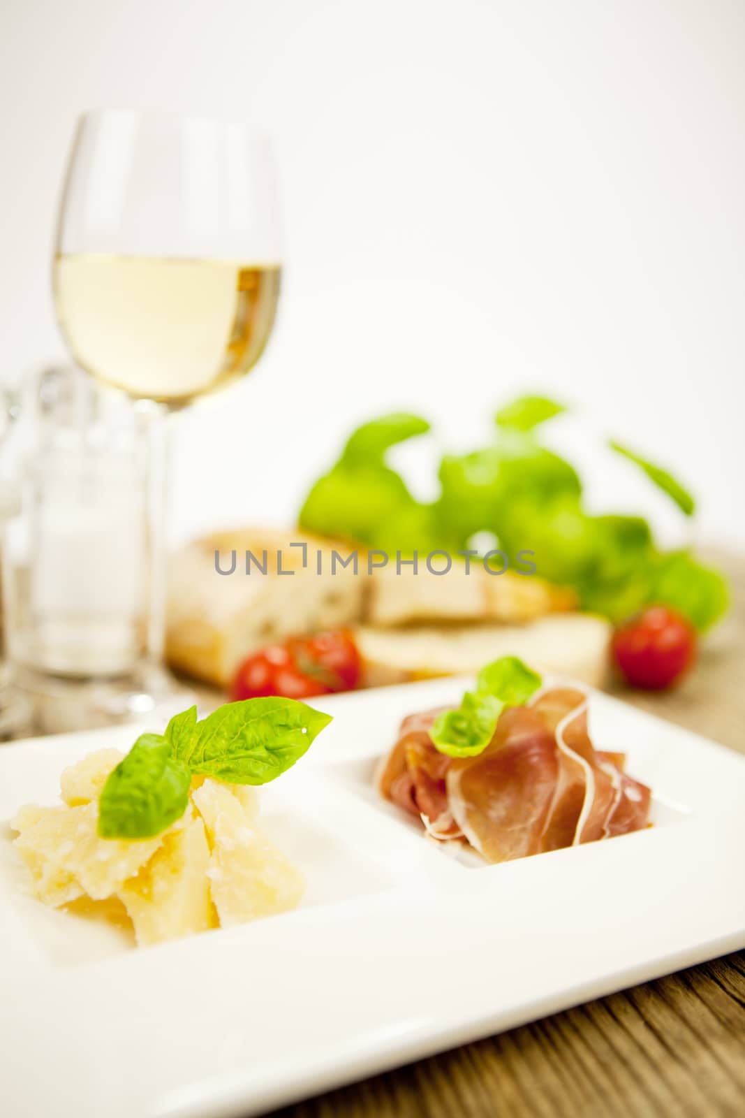 deliscious antipasti plate with parma parmesan olives on wooden background