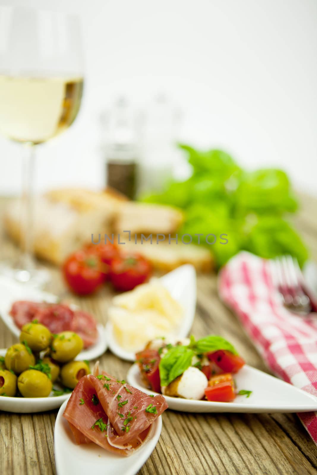 deliscious antipasti plate with parma parmesan olives on wooden background